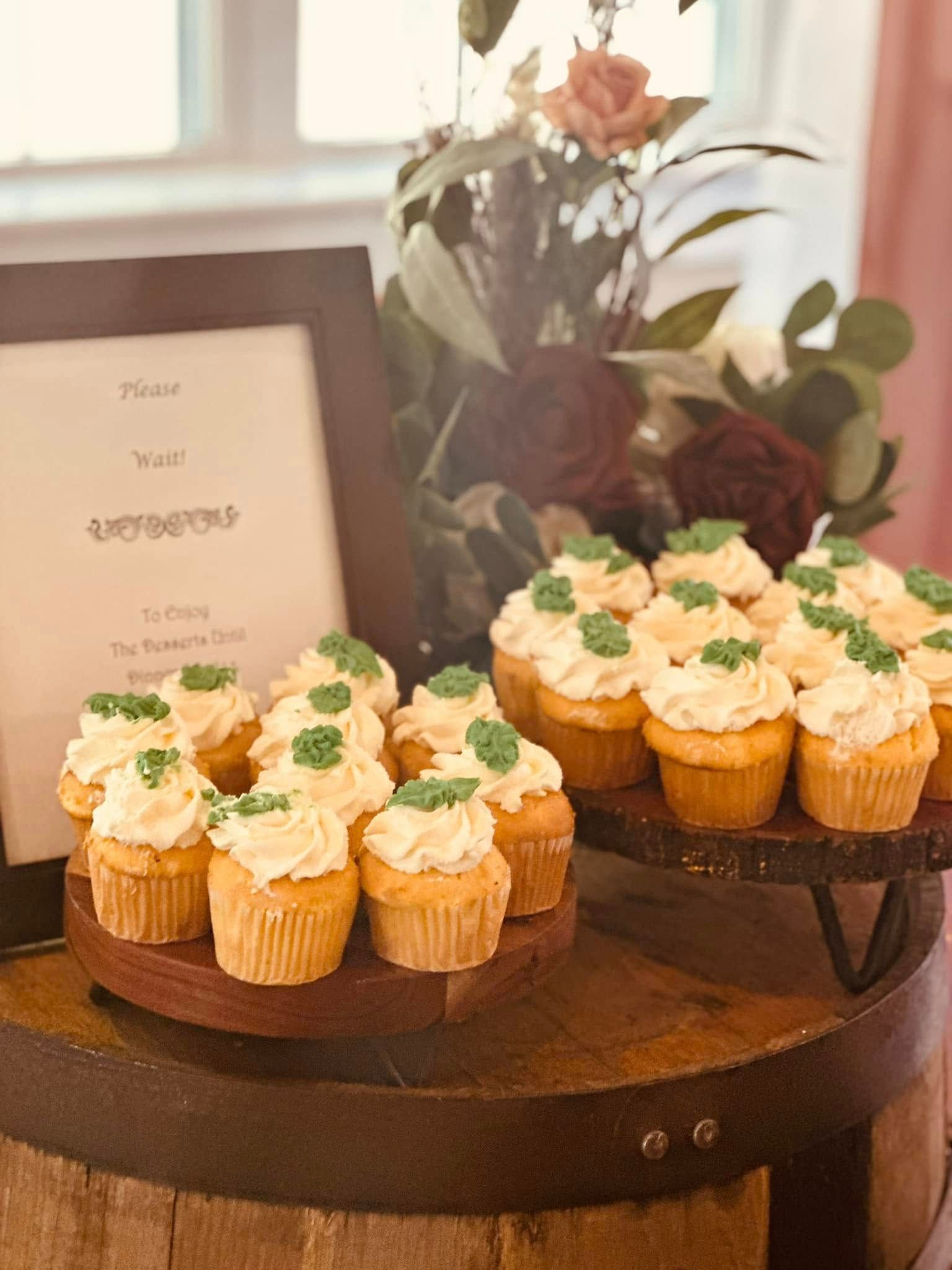A bunch of cupcakes are sitting on top of a wooden barrel.
