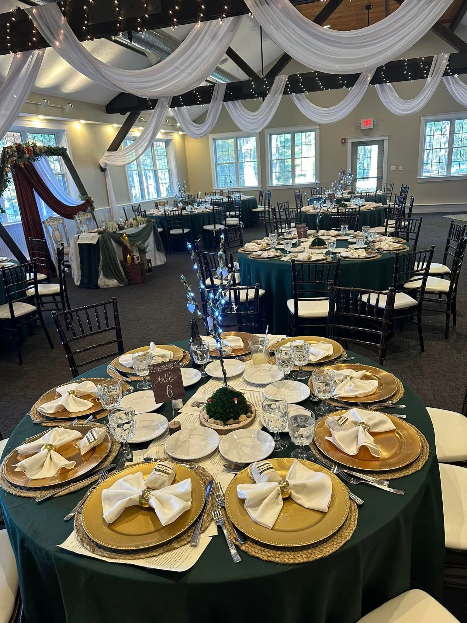 A large room with tables and chairs set up for a wedding reception.