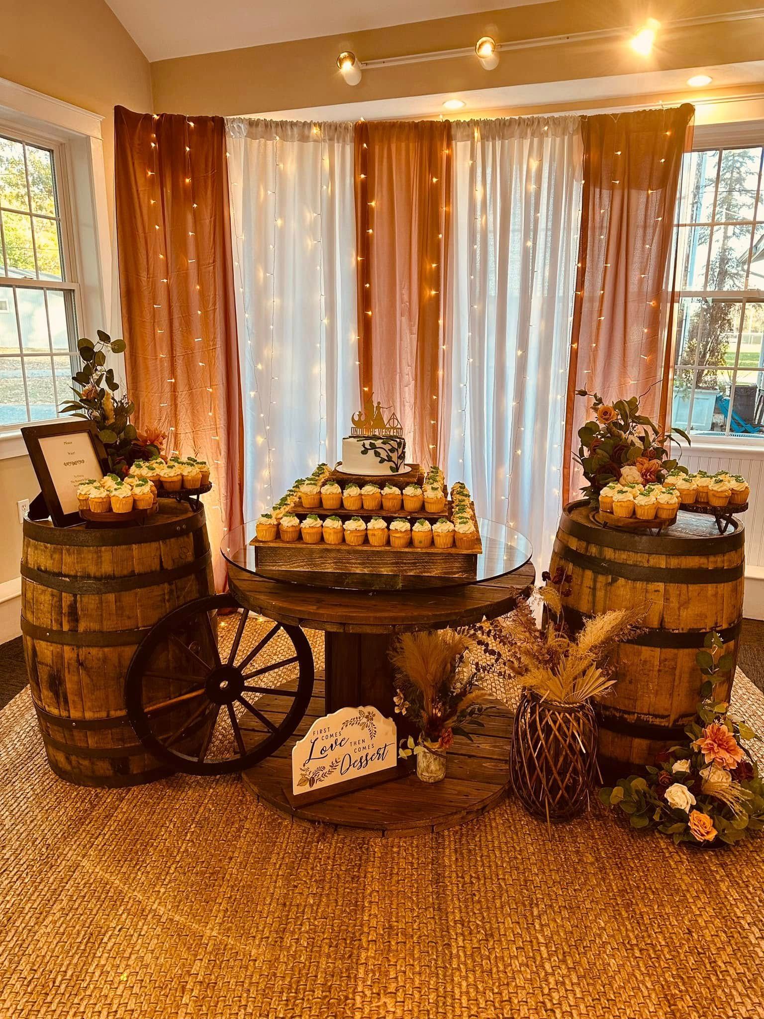 A table with candles on it and barrels in a room.