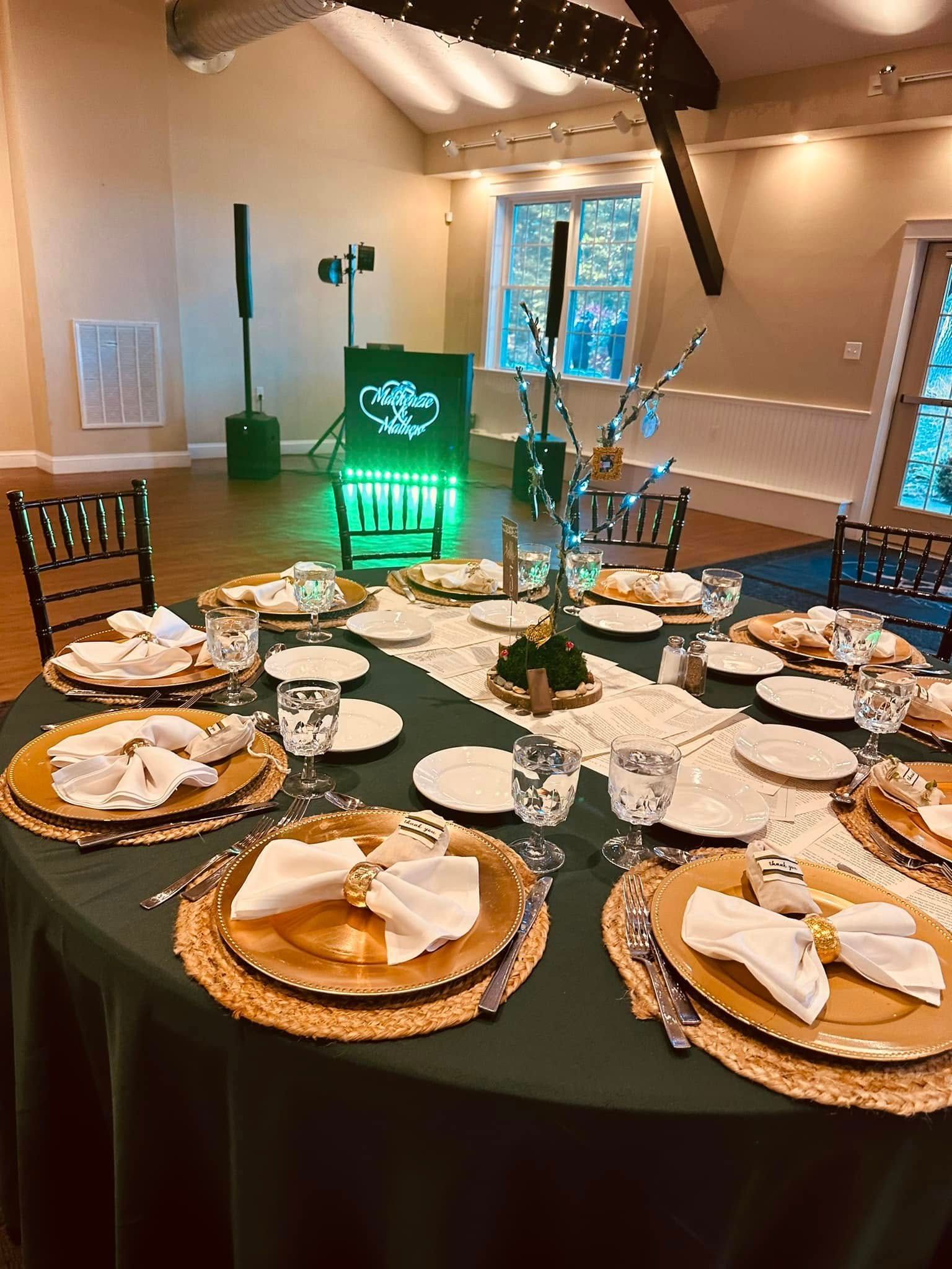 A table set for a wedding reception with plates , glasses , and napkins.