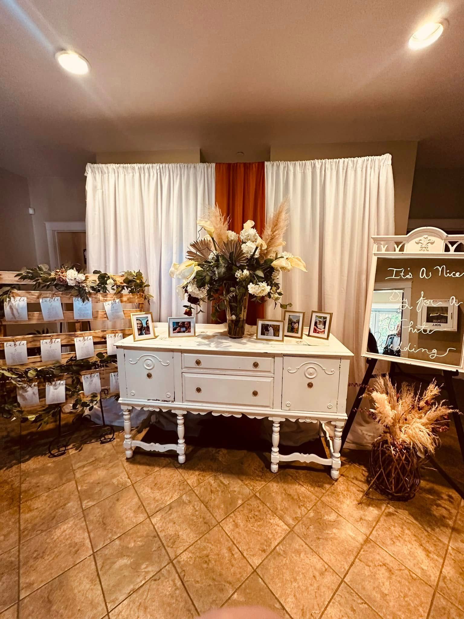 There is a table with flowers on it in the middle of the room.