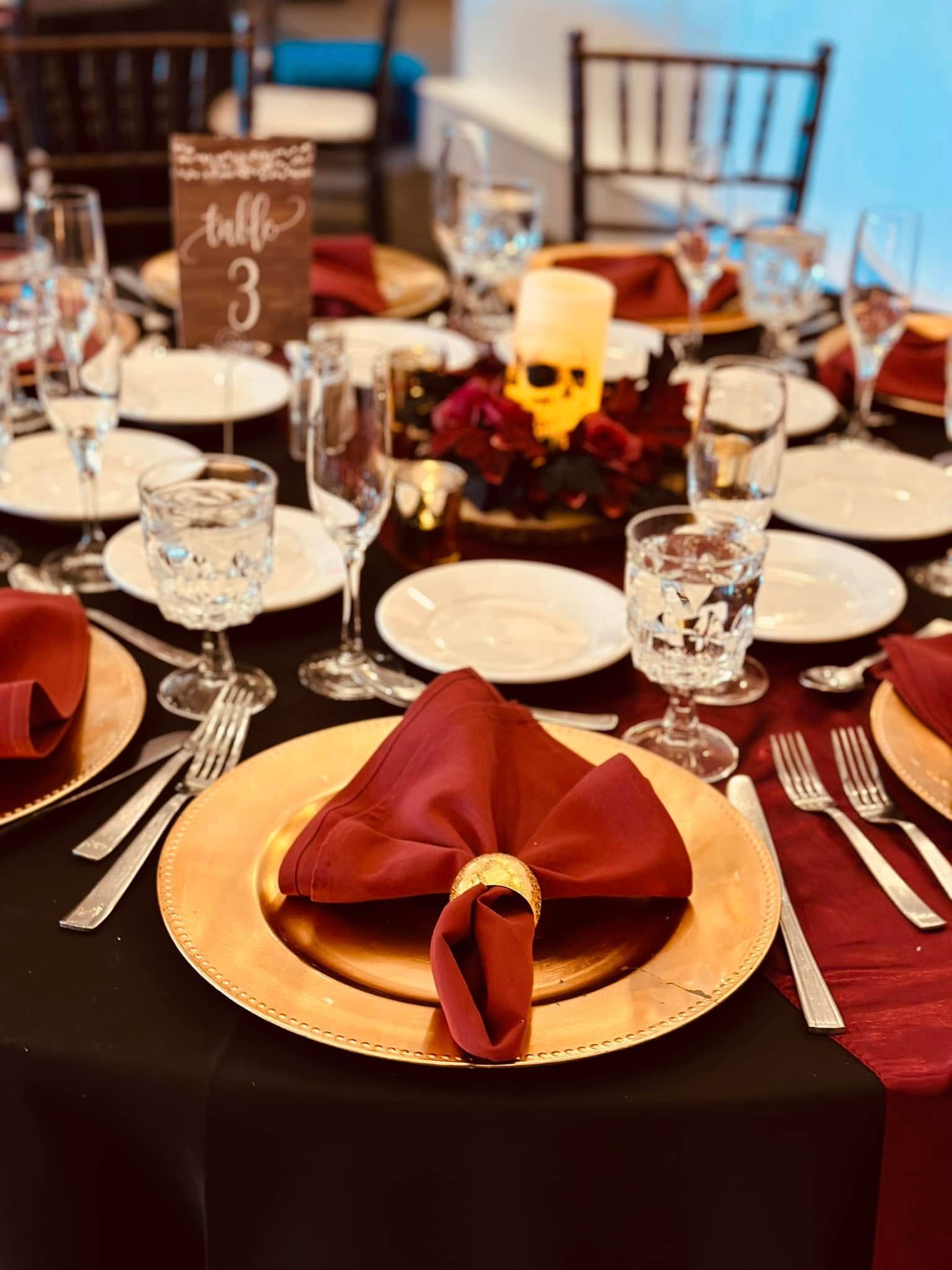 A table set for a wedding reception with plates , napkins , glasses , and candles.
