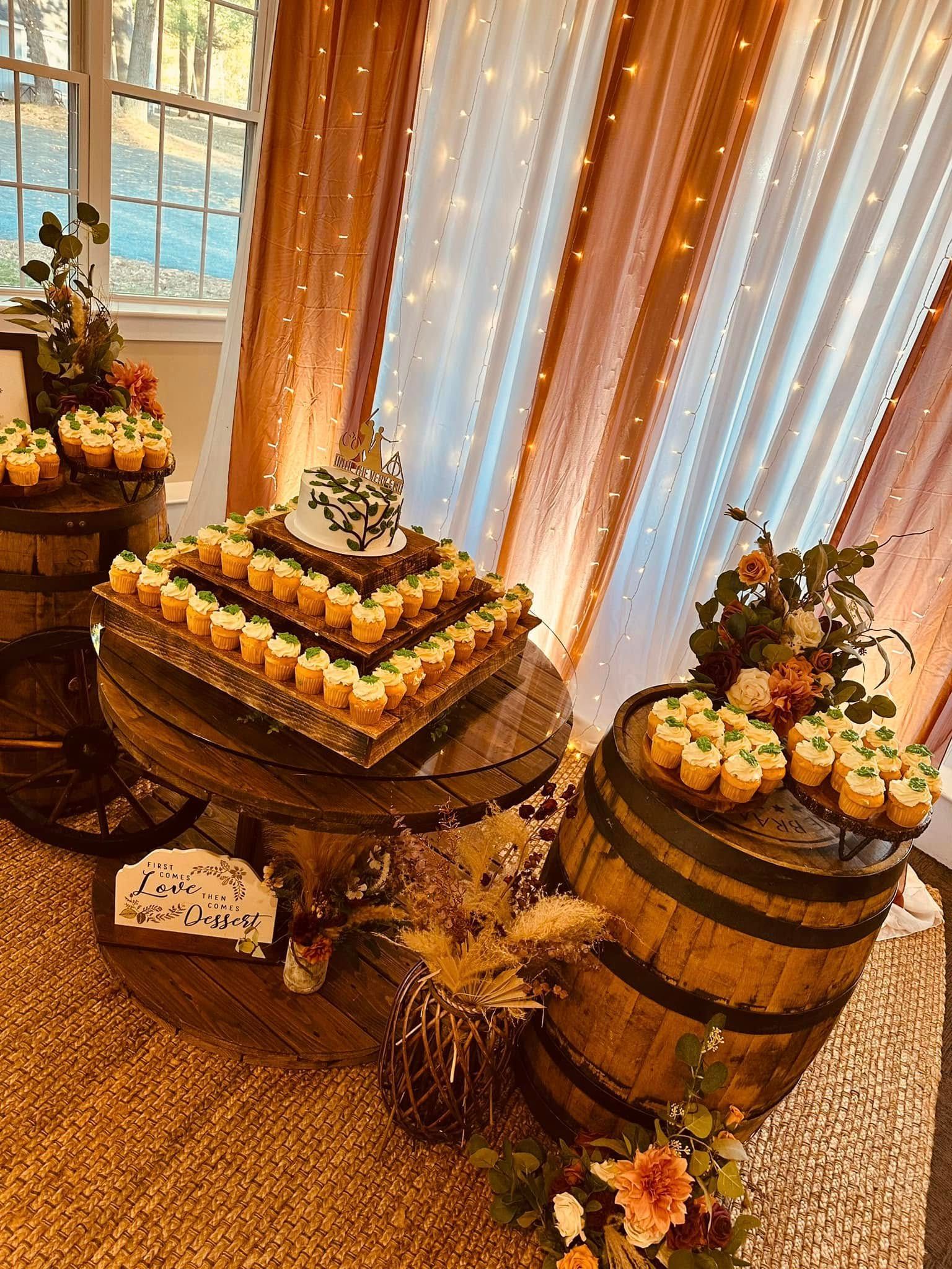 A table with a cake and cupcakes on it.