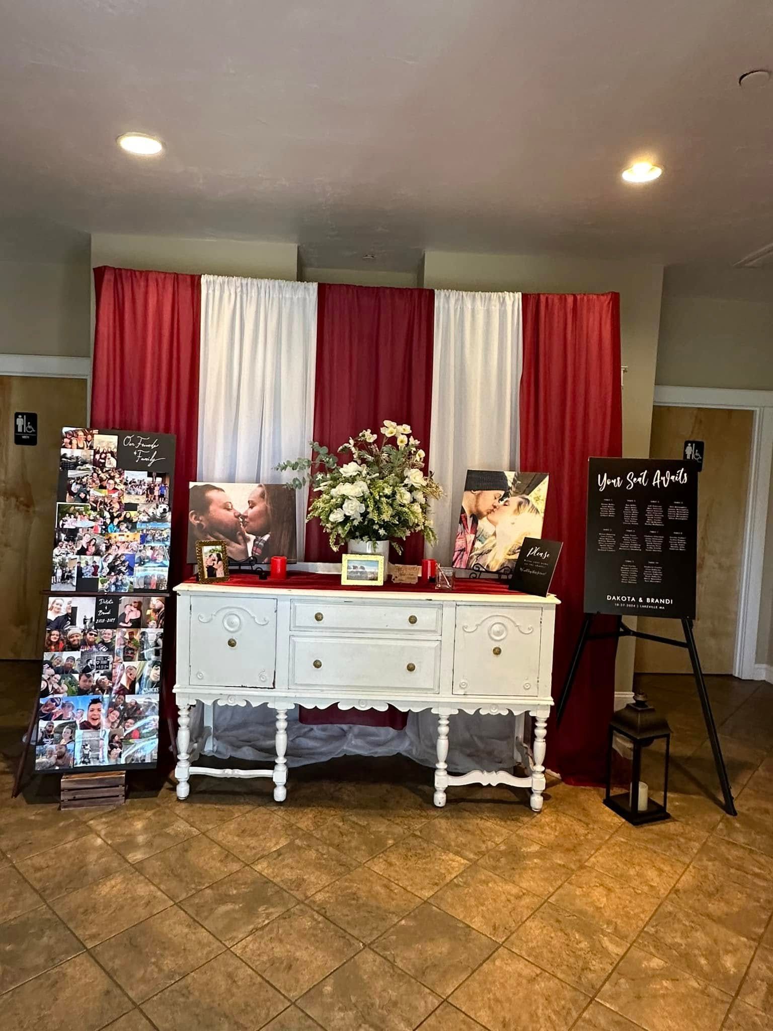 A white dresser is sitting in front of a red and white curtain in a room.