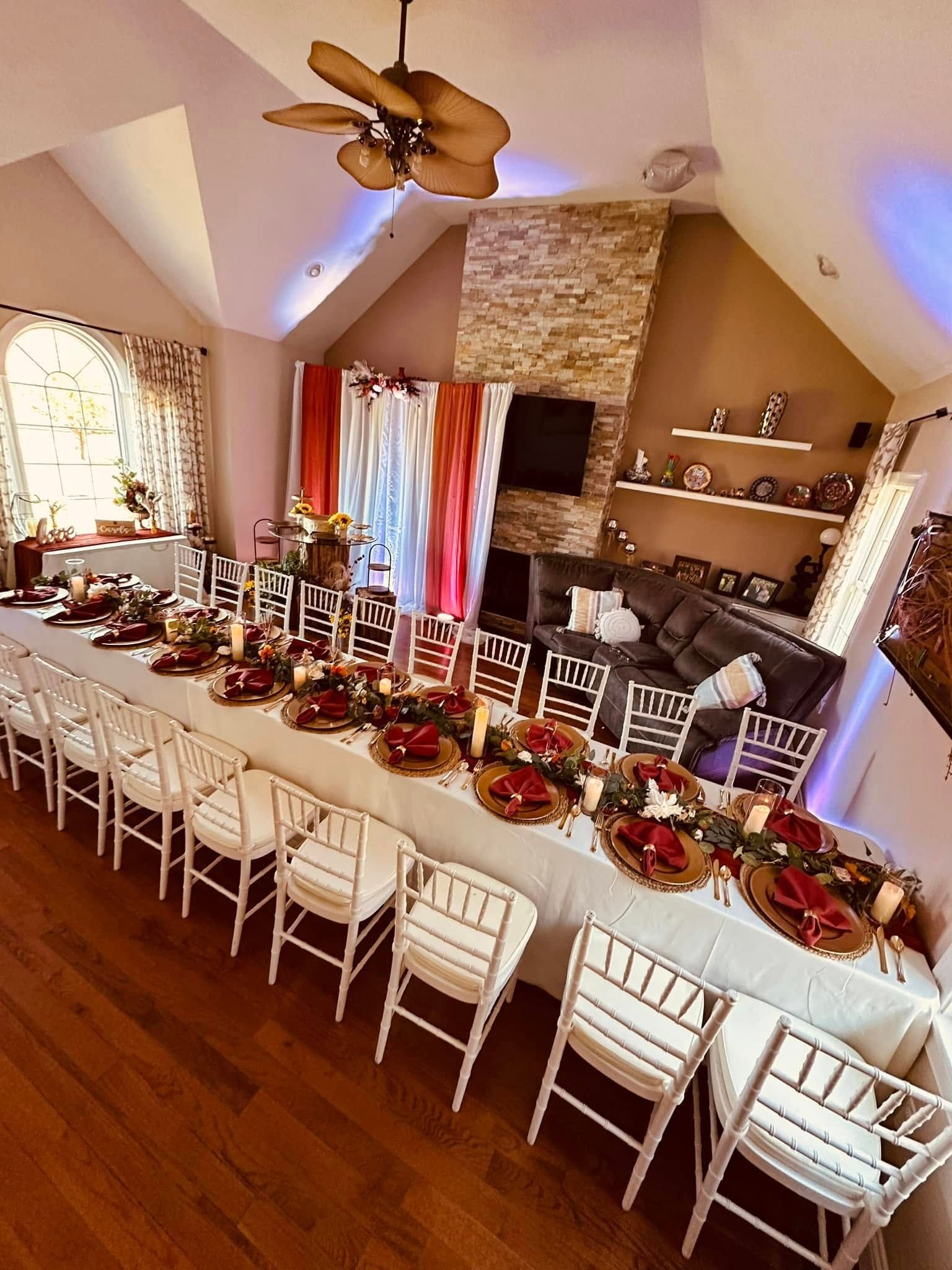 A long table and chairs in a living room with a ceiling fan.
