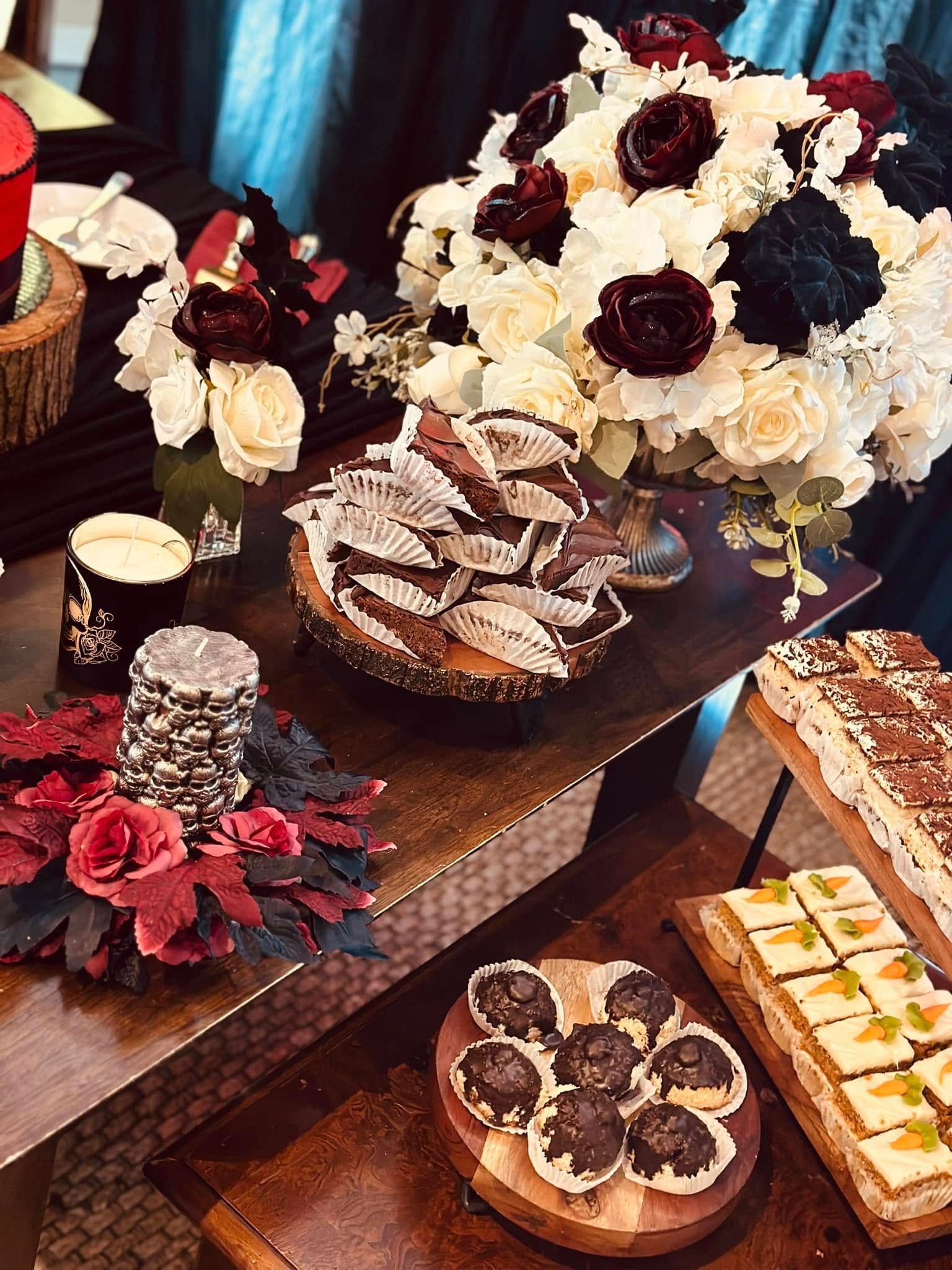 A table topped with a variety of desserts and flowers.