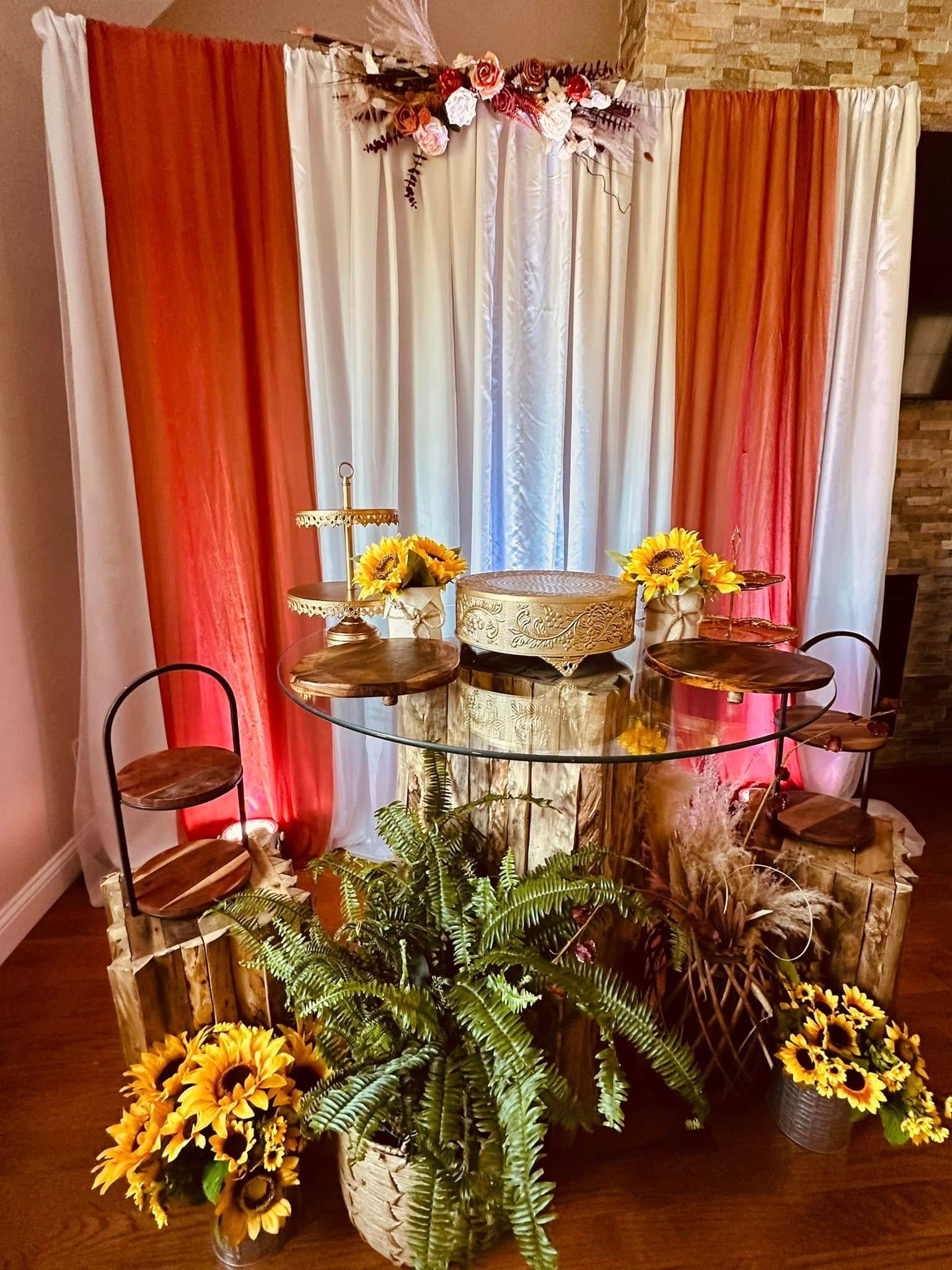 There is a table with a cake on it in the middle of the room.
