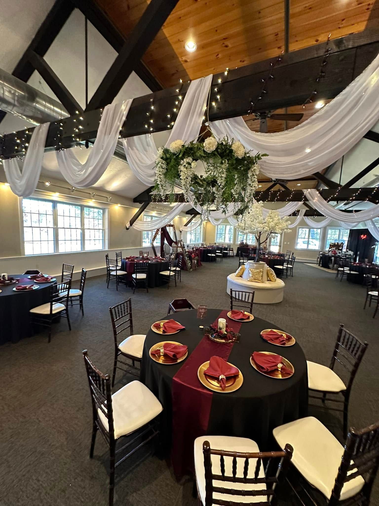 A large room with tables and chairs set up for a wedding reception.