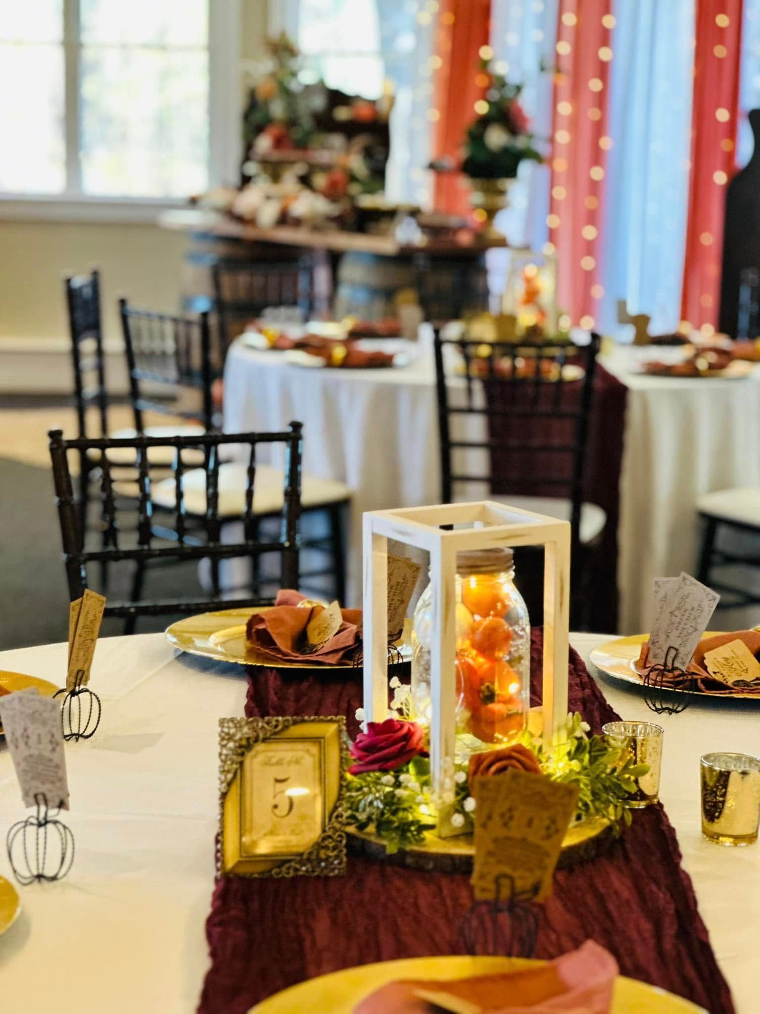 A table with plates , napkins , candles , and a lantern on it.
