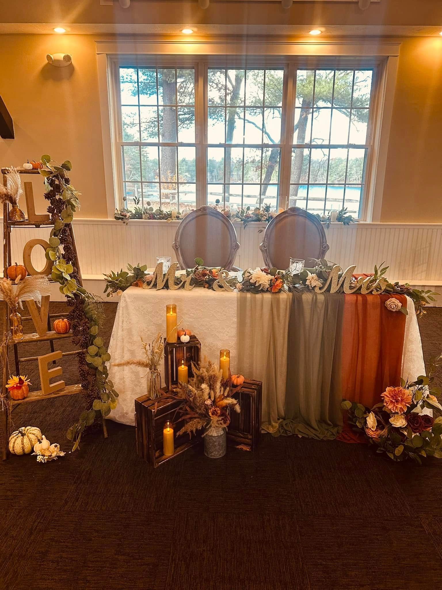 A couple 's head table is decorated with candles and flowers.