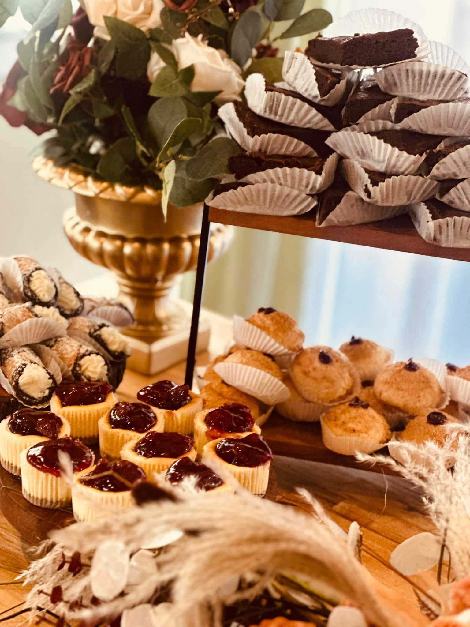 A table topped with cupcakes and a vase of flowers.