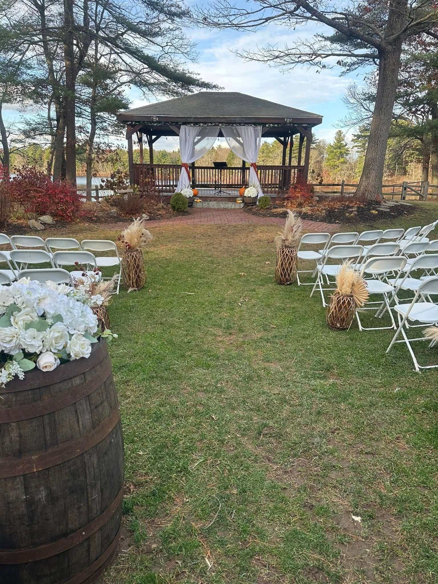 A gazebo is sitting in the middle of a lush green field surrounded by trees.
