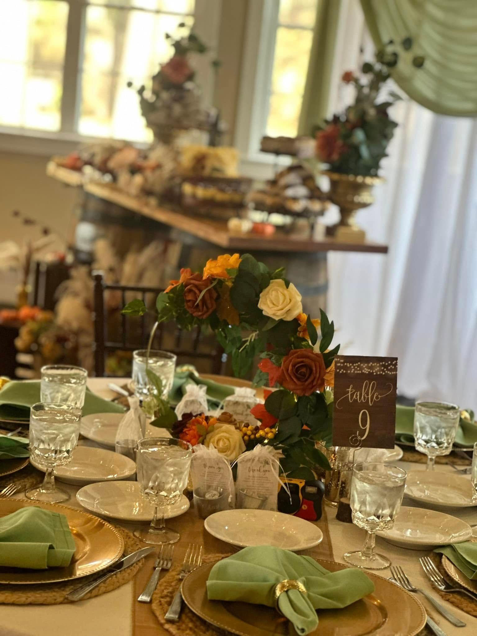 A table set for a wedding reception with plates , glasses , napkins and flowers.