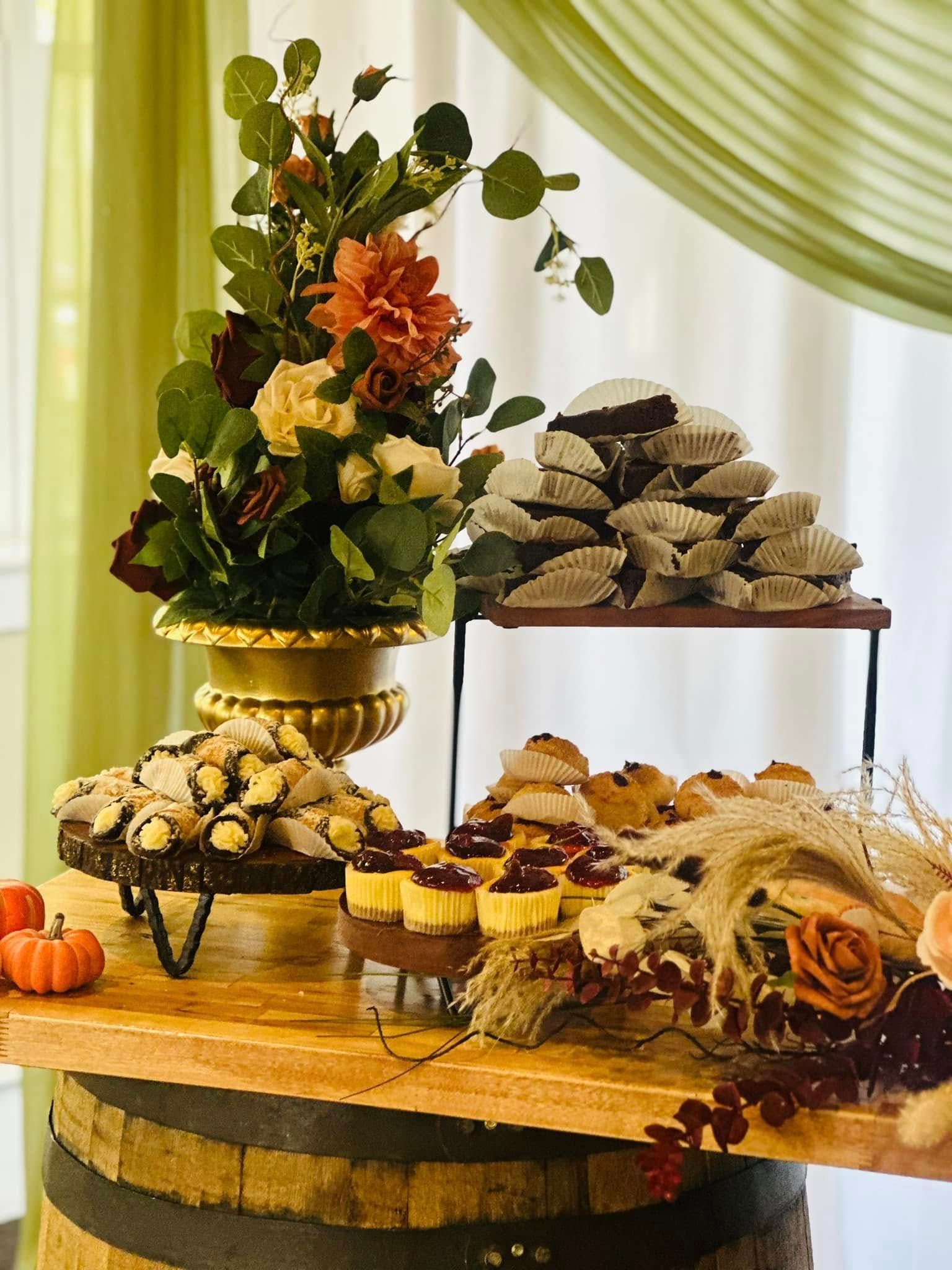 A table with a variety of desserts and flowers on it