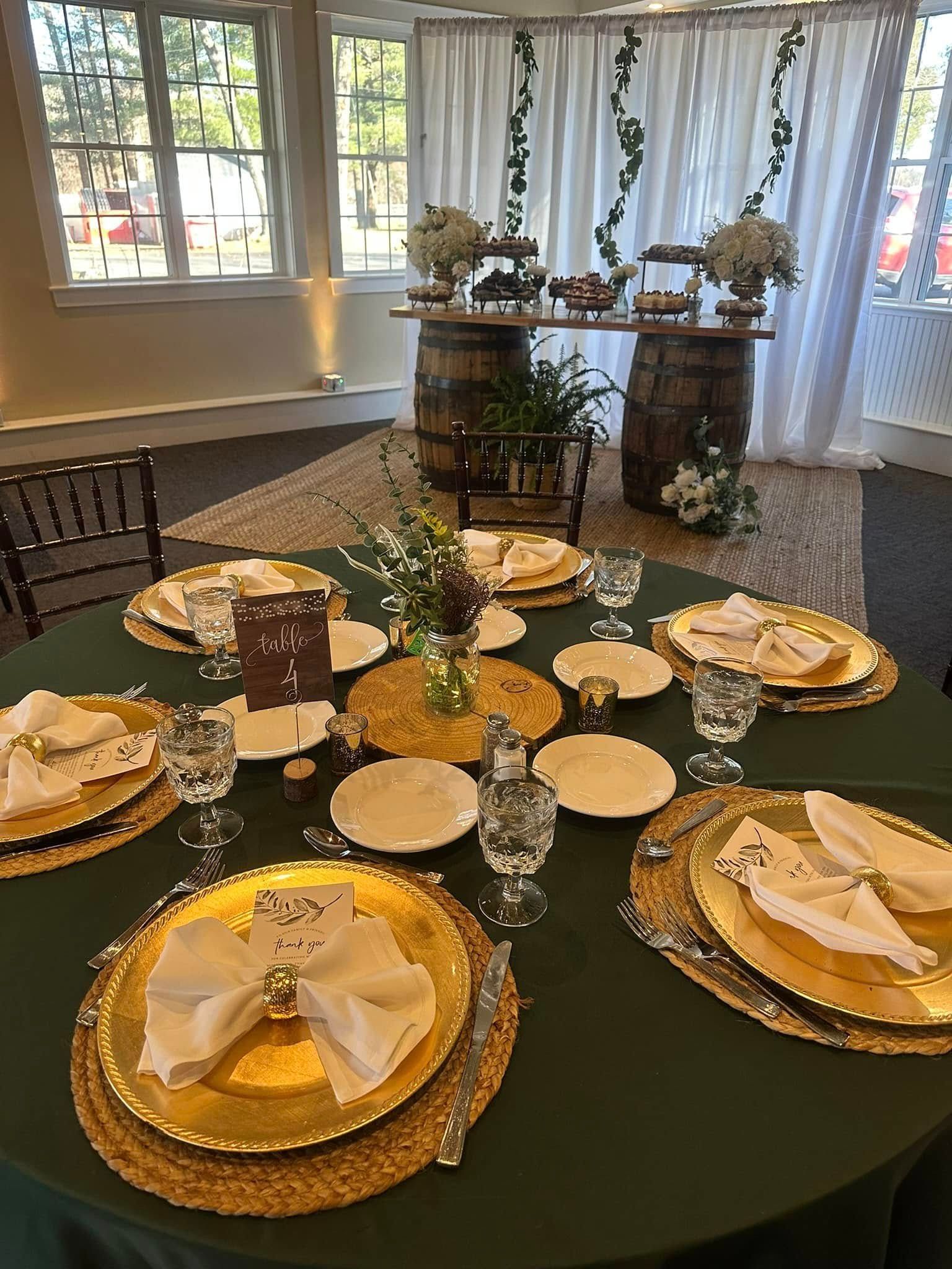 A table set for a wedding reception with plates , glasses , and napkins.