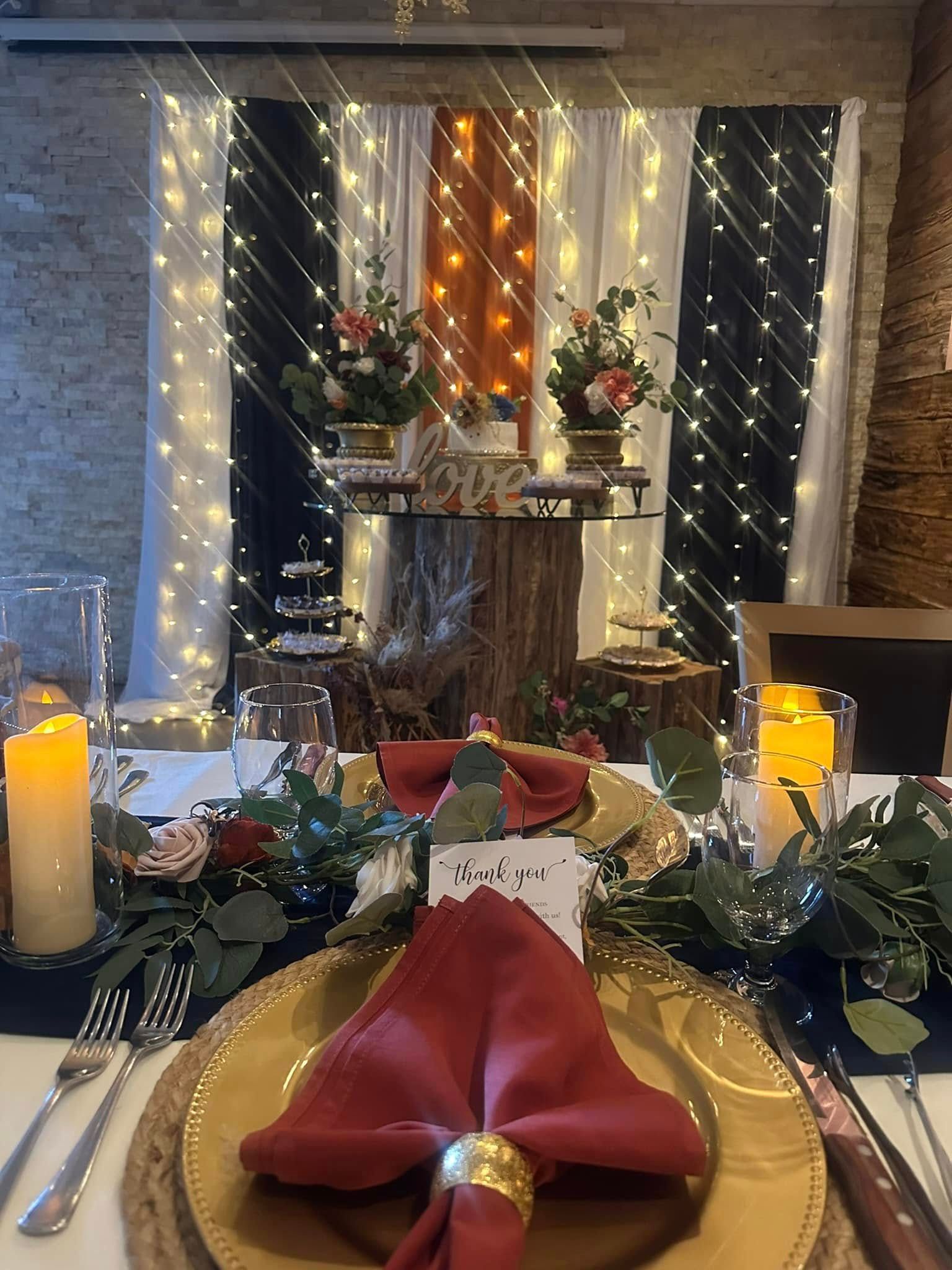A table set for a wedding reception with plates , napkins , candles and flowers.