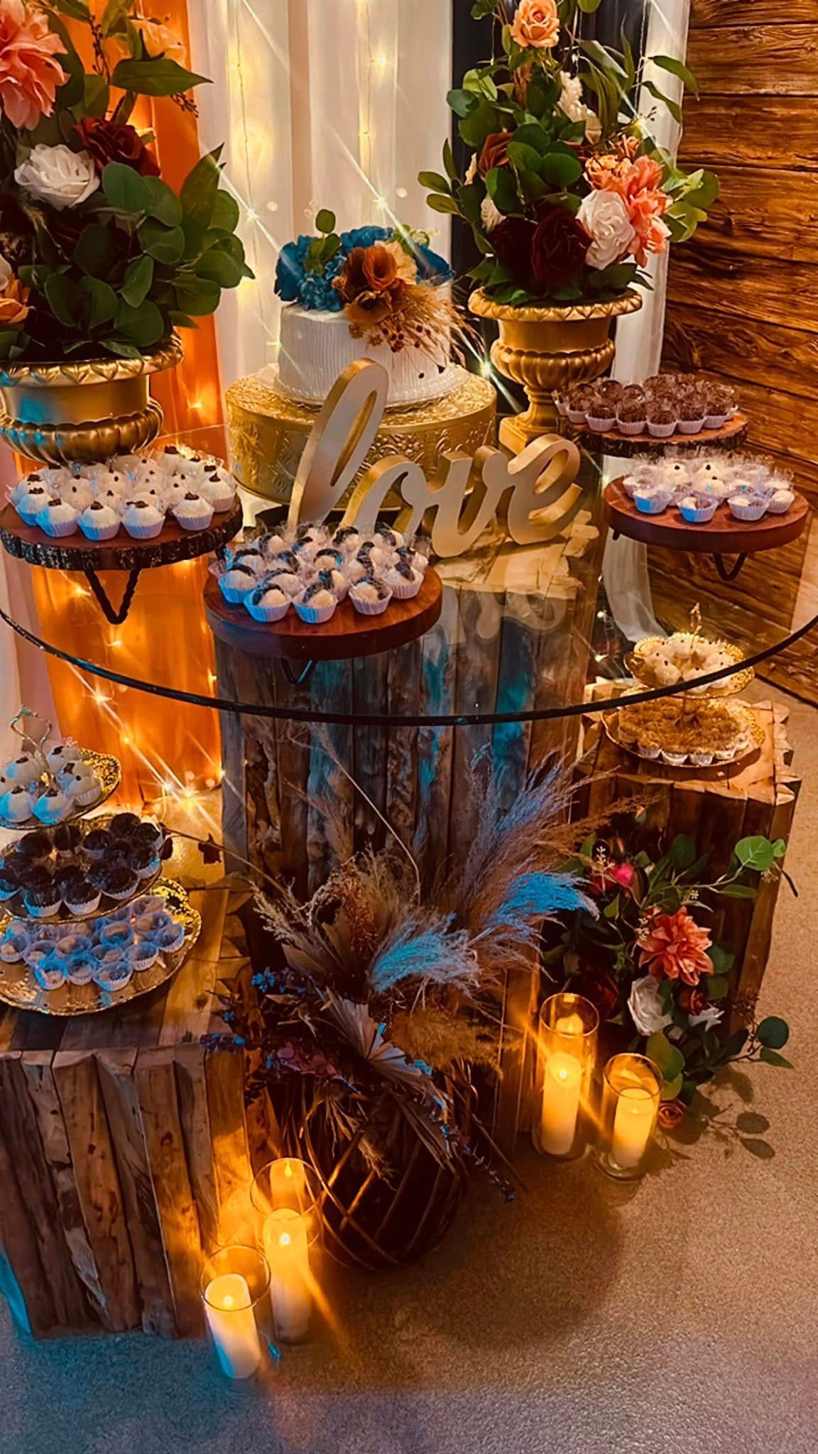 A glass table topped with cupcakes and a cake.