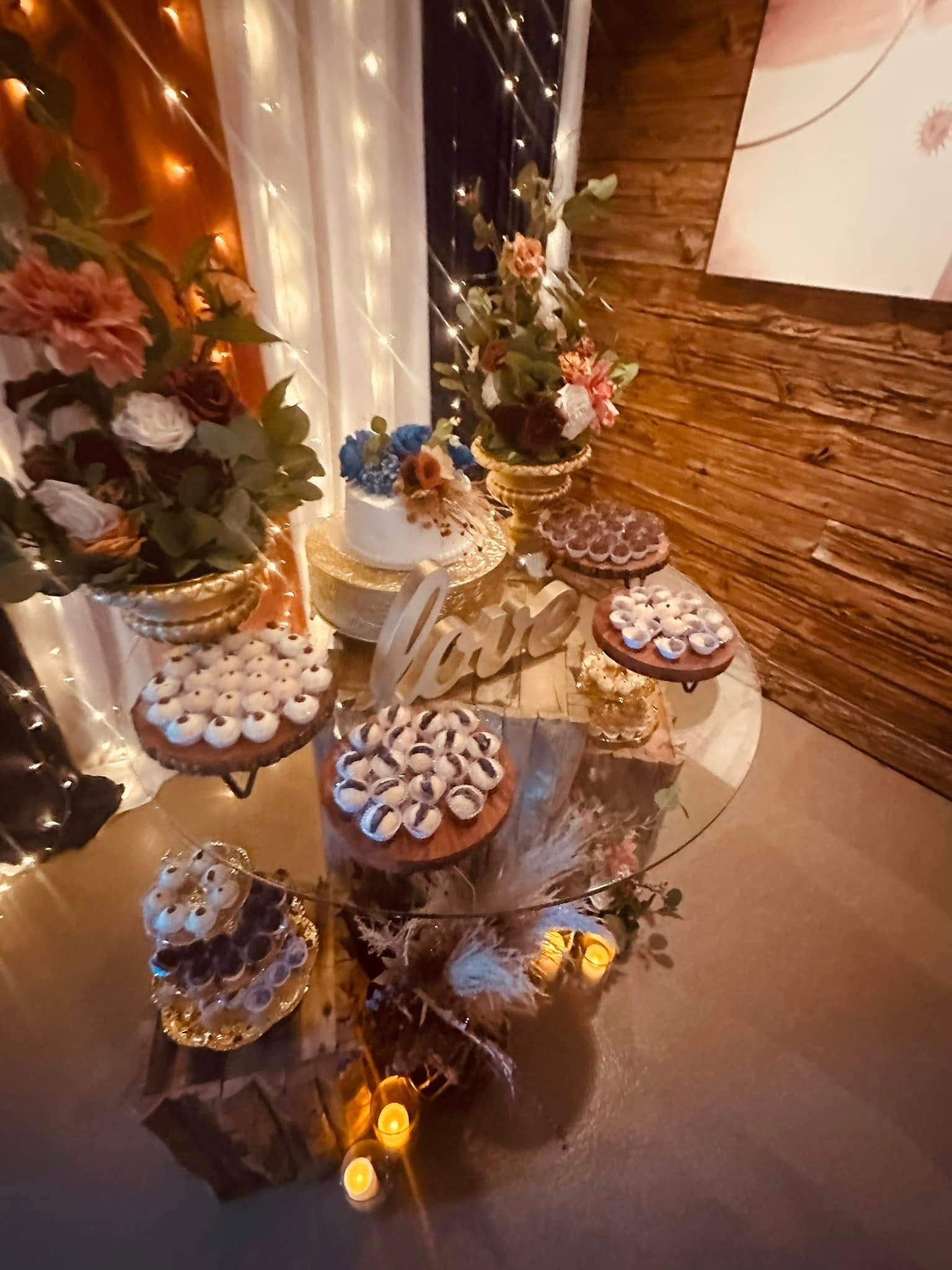 A table with a variety of desserts and flowers on it.