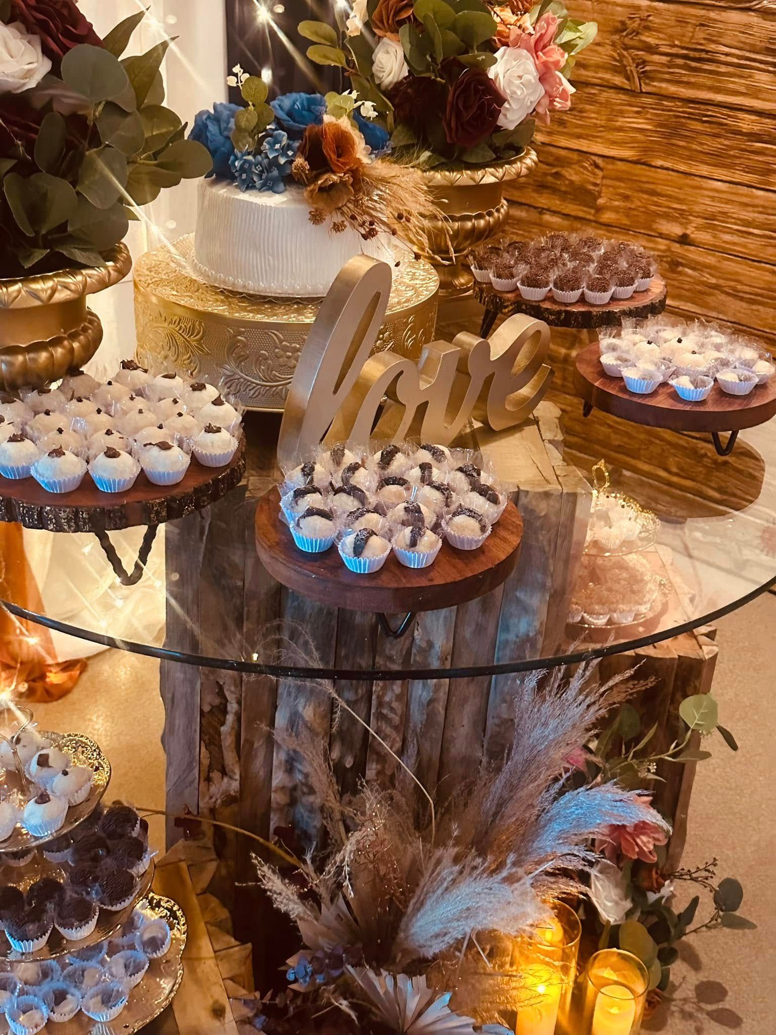 A glass table topped with cupcakes and a cake.