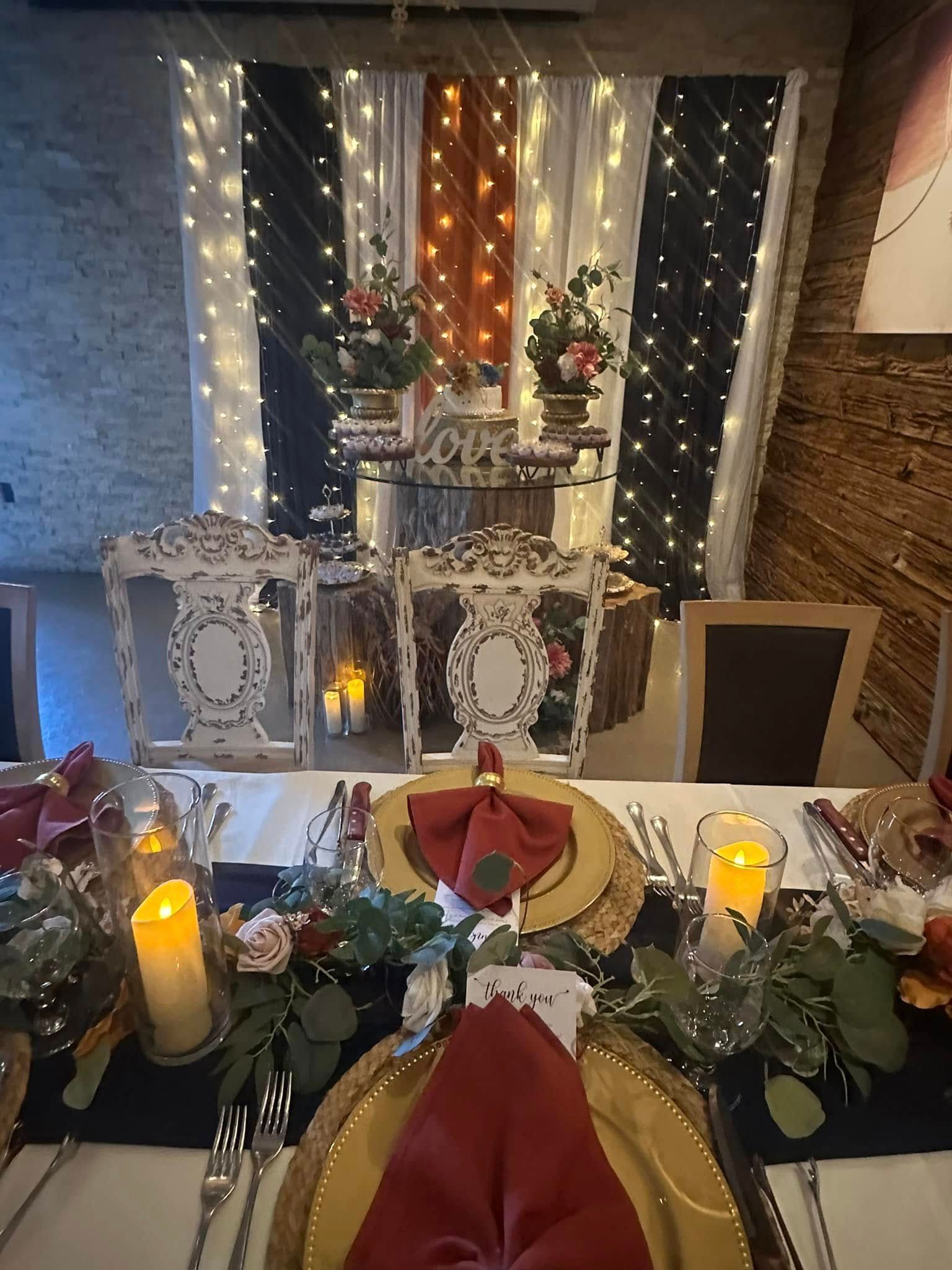 A table set for a wedding reception with plates , napkins , candles and flowers.
