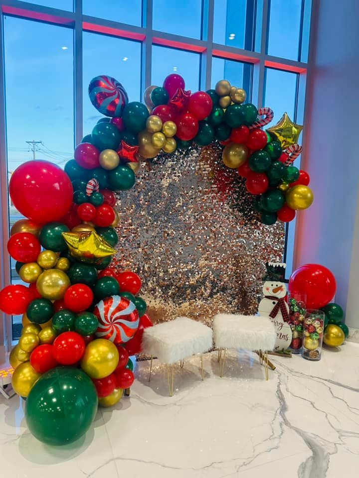 A bunch of balloons are sitting on a table in front of a window.