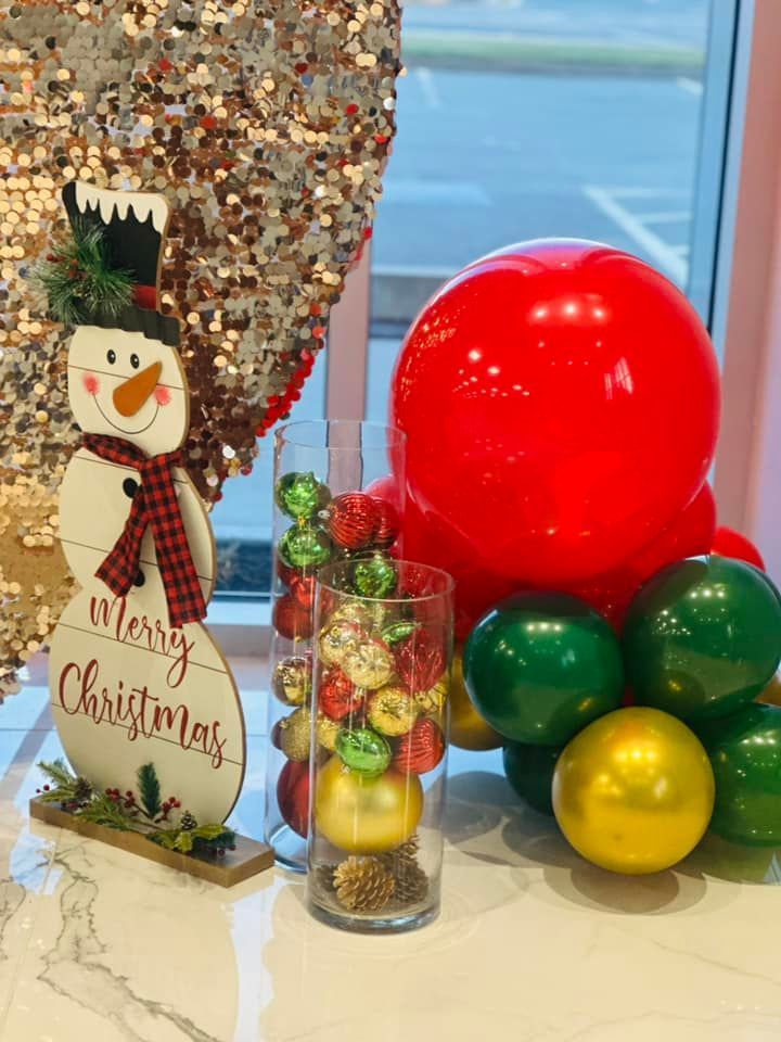 A christmas decoration with balloons and a snowman on a table.