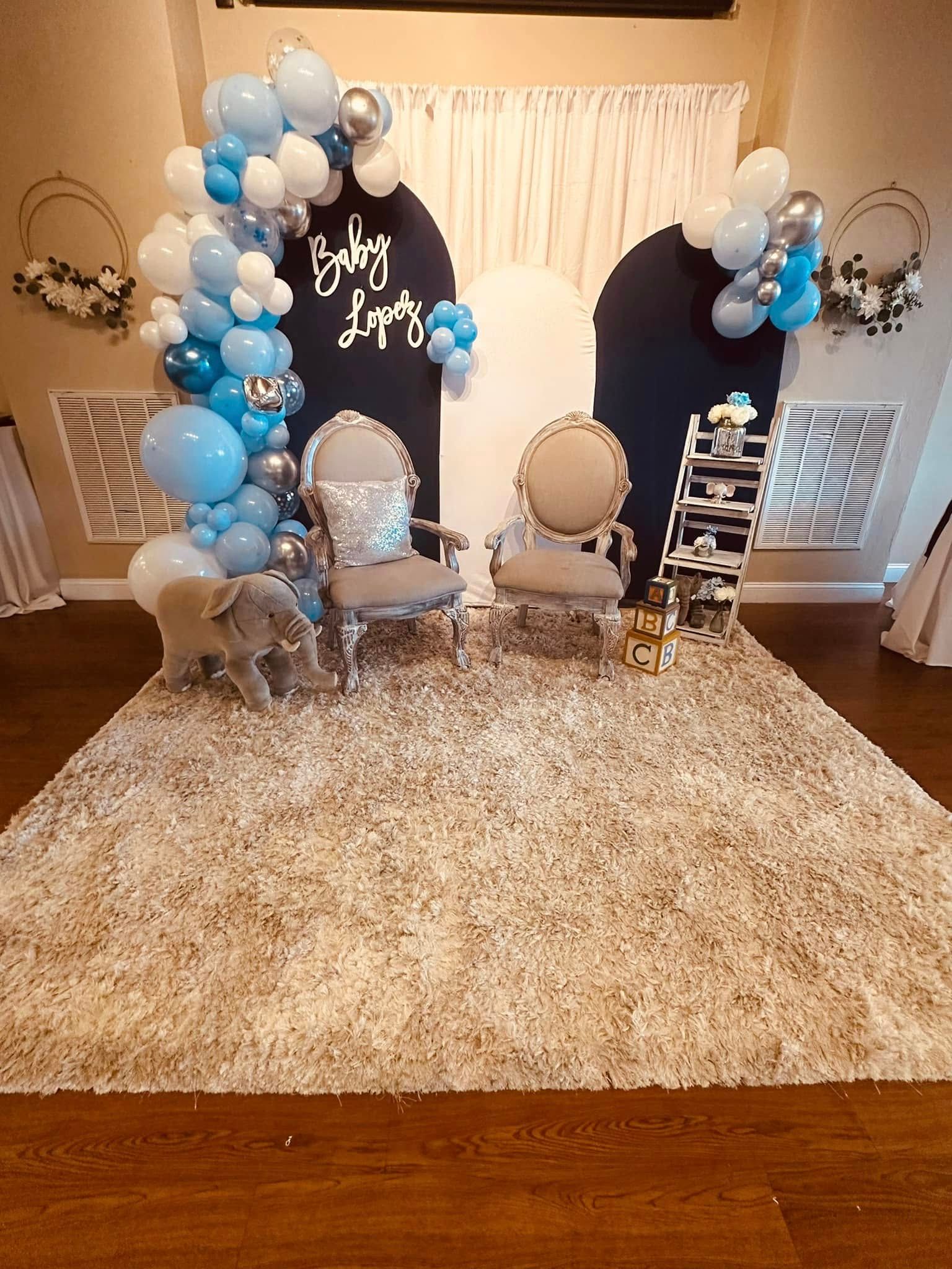 A room filled with furniture and balloons for a baby shower.