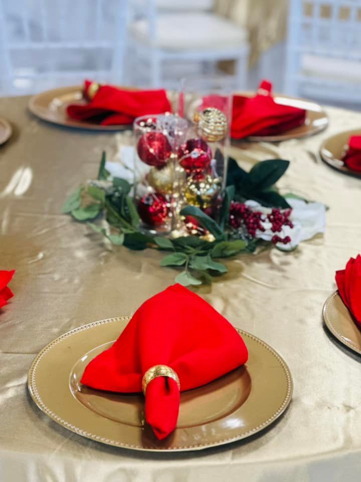 A table setting with red napkins and gold plates