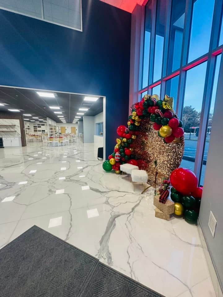 A large room with a christmas tree and balloons in it
