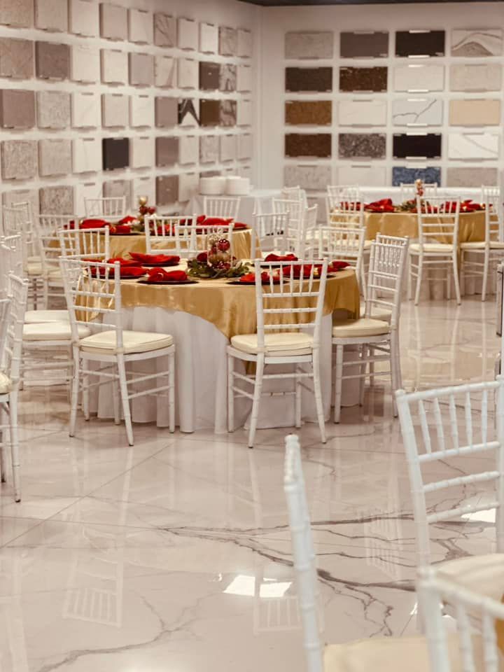 A large room with tables and chairs set up for a party.