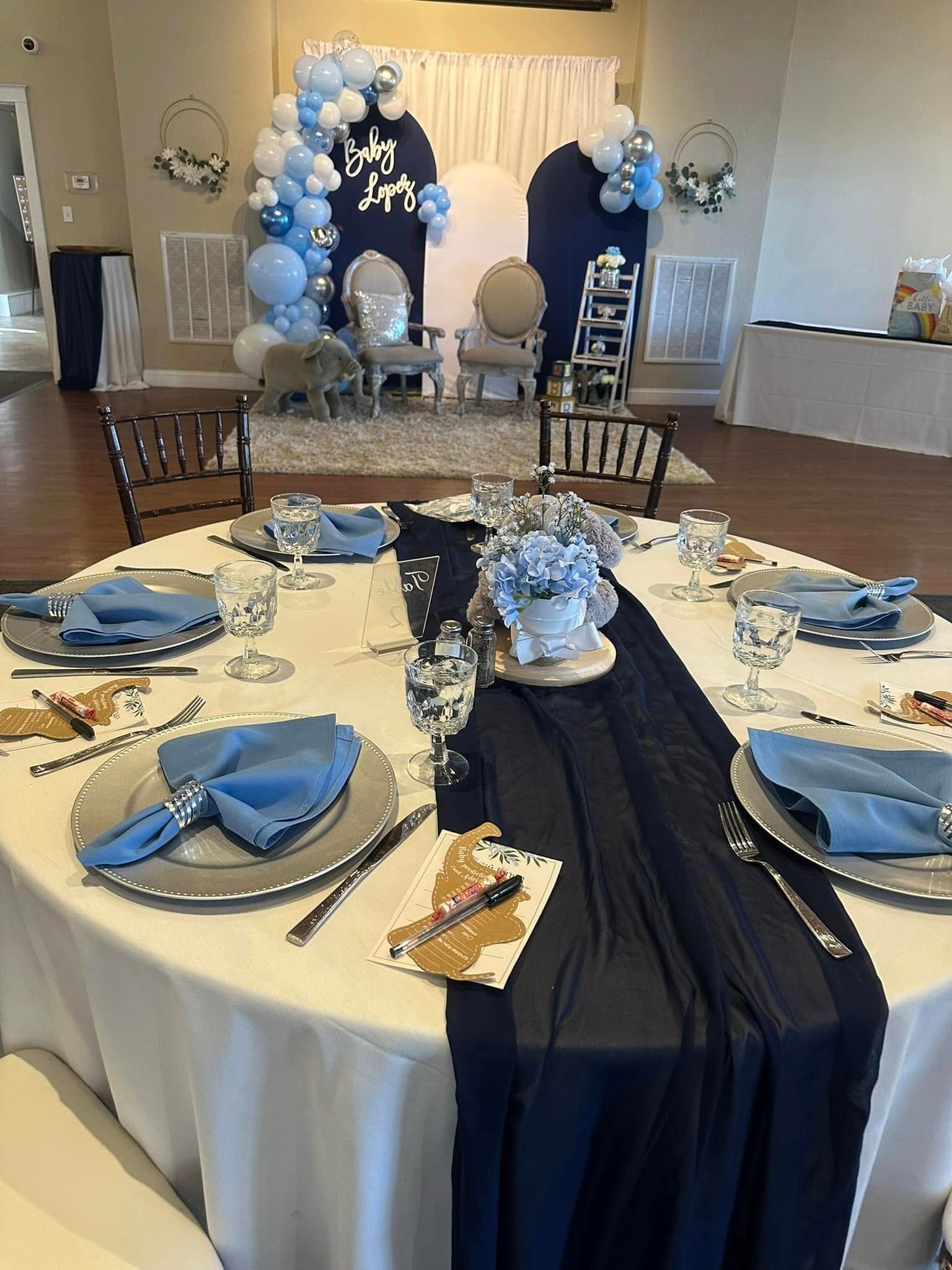 A table set for a baby shower with plates , napkins , and glasses.