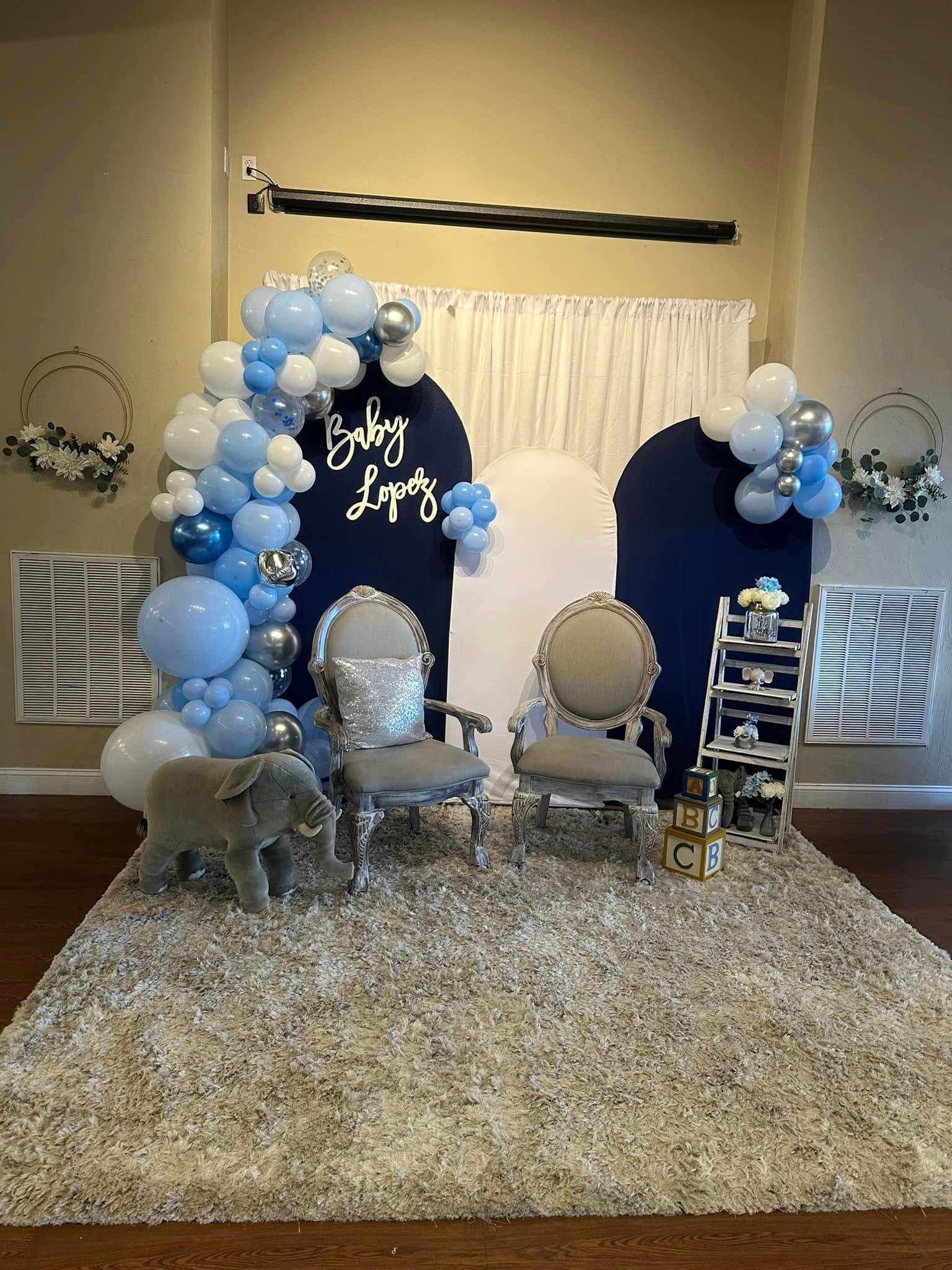 A room filled with furniture and balloons for a baby shower.