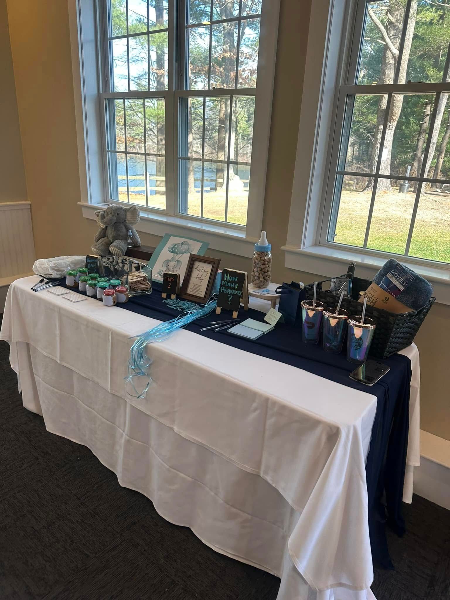 A table with a white table cloth is sitting in front of a window.