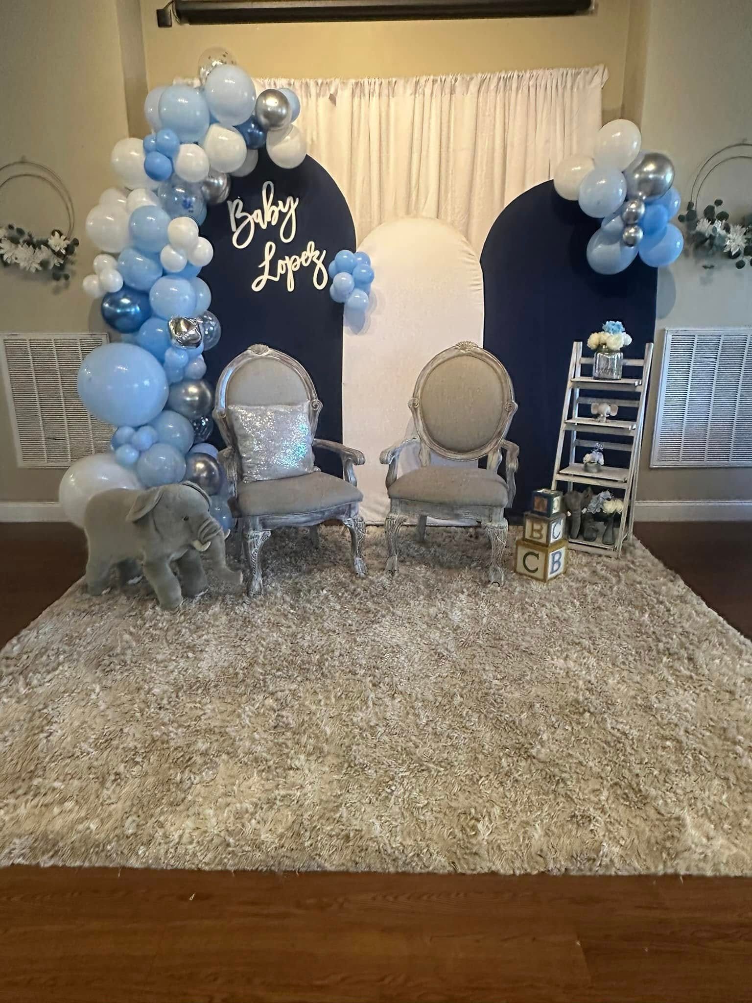 A room decorated with balloons and chairs for a baby shower.