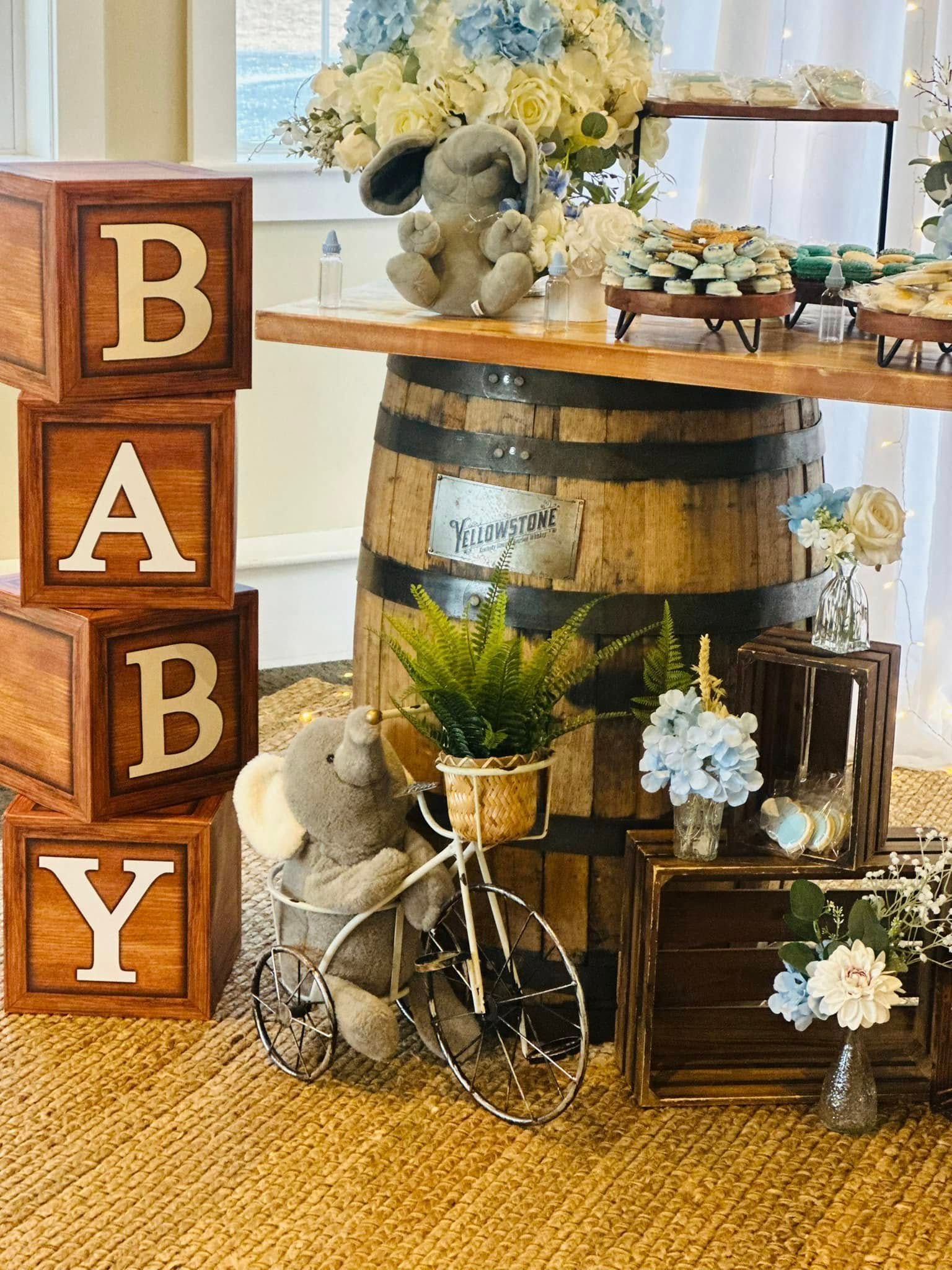 A baby shower with wooden blocks and a stuffed elephant on a bicycle.