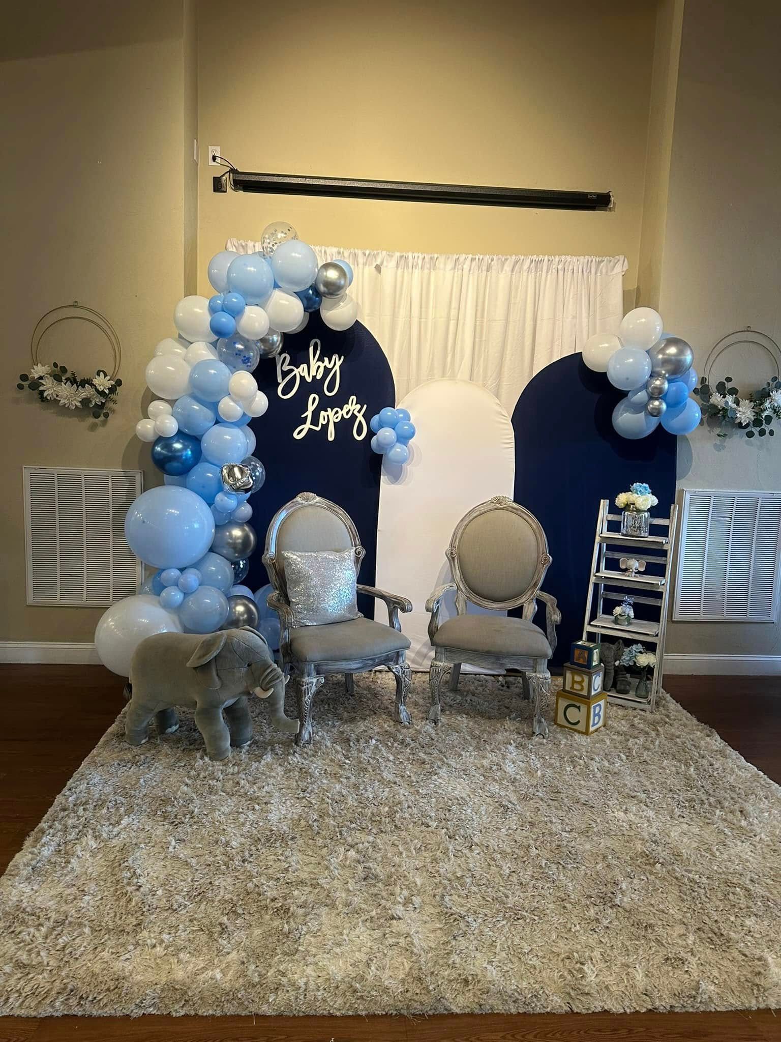 A room filled with furniture and balloons for a baby shower.