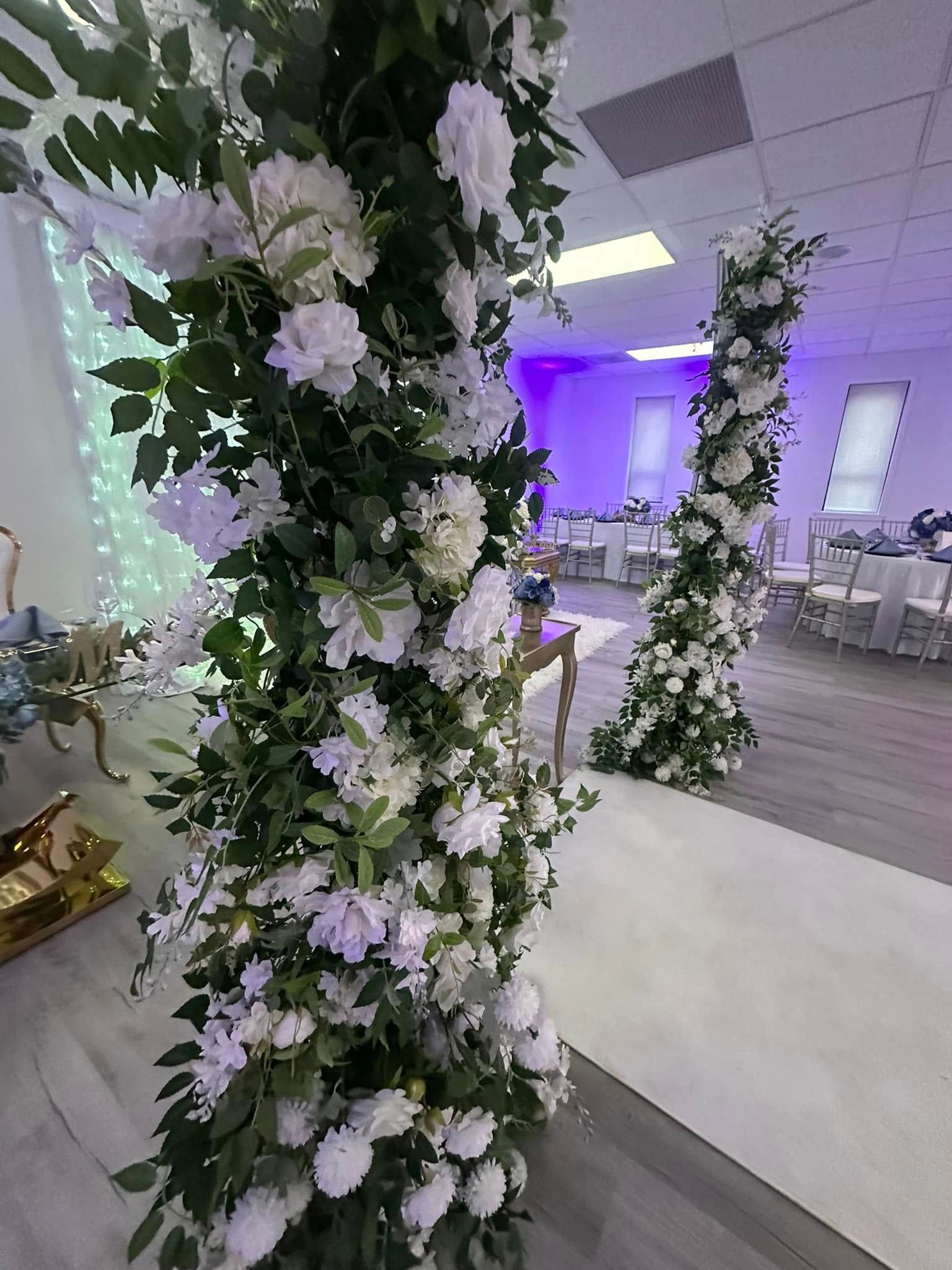 A room decorated with white flowers and greenery for a wedding.