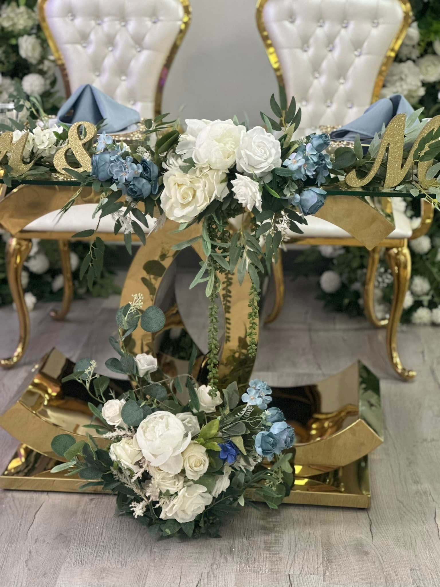 A couple of chairs sitting next to a table with flowers on it.