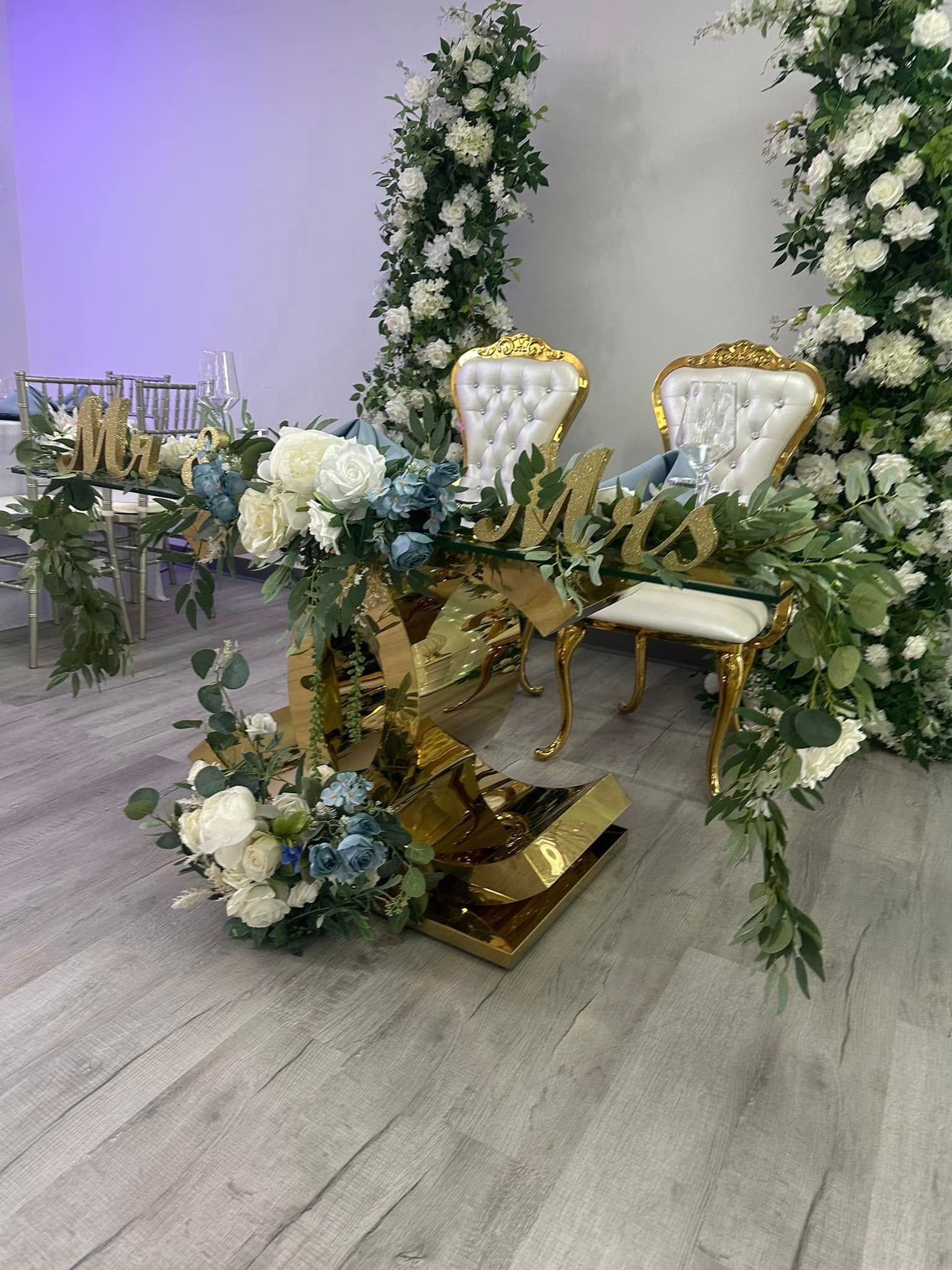 A couple of chairs sitting next to a table with flowers on it.