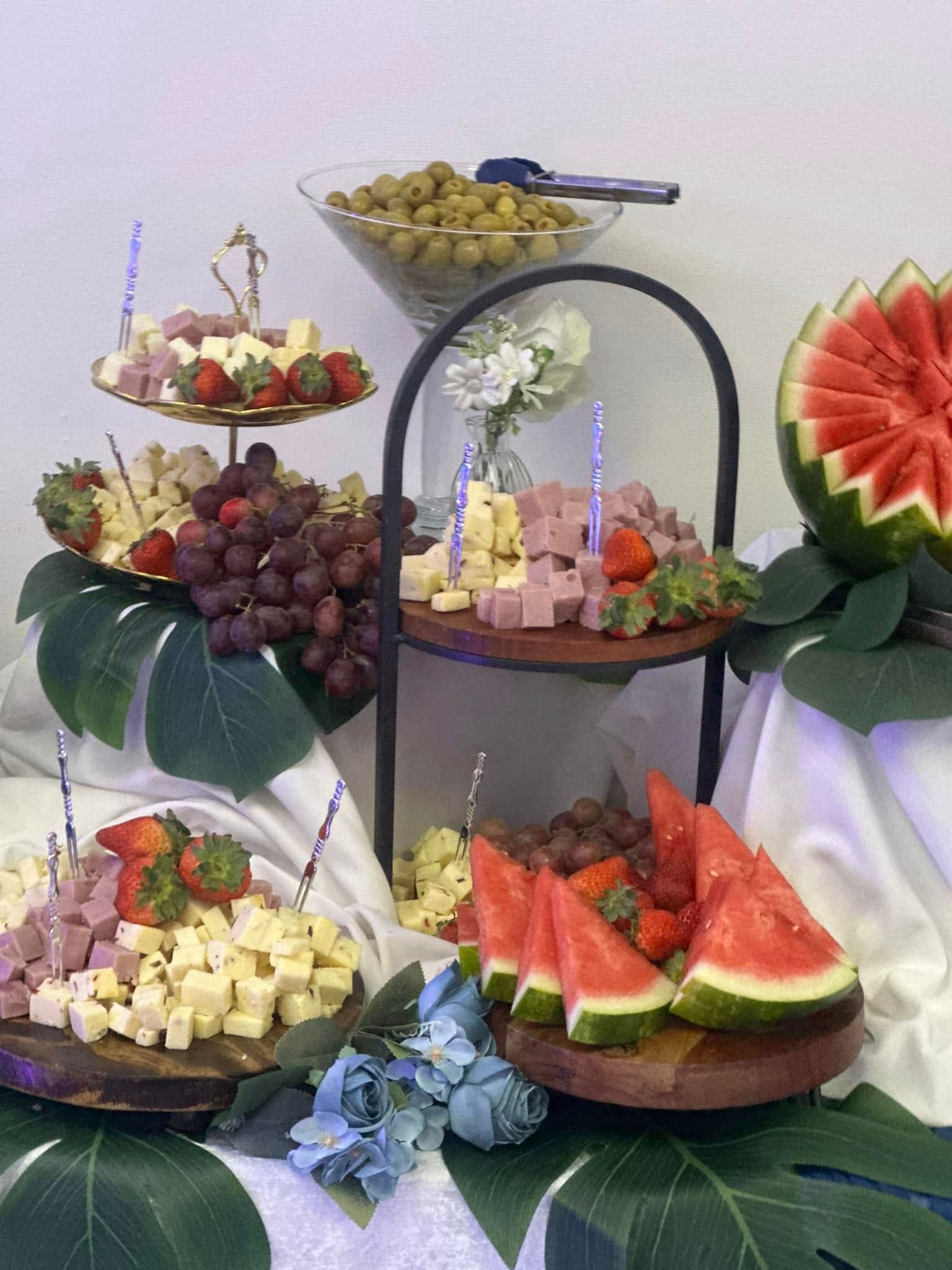 A table topped with plates of food and watermelon slices.