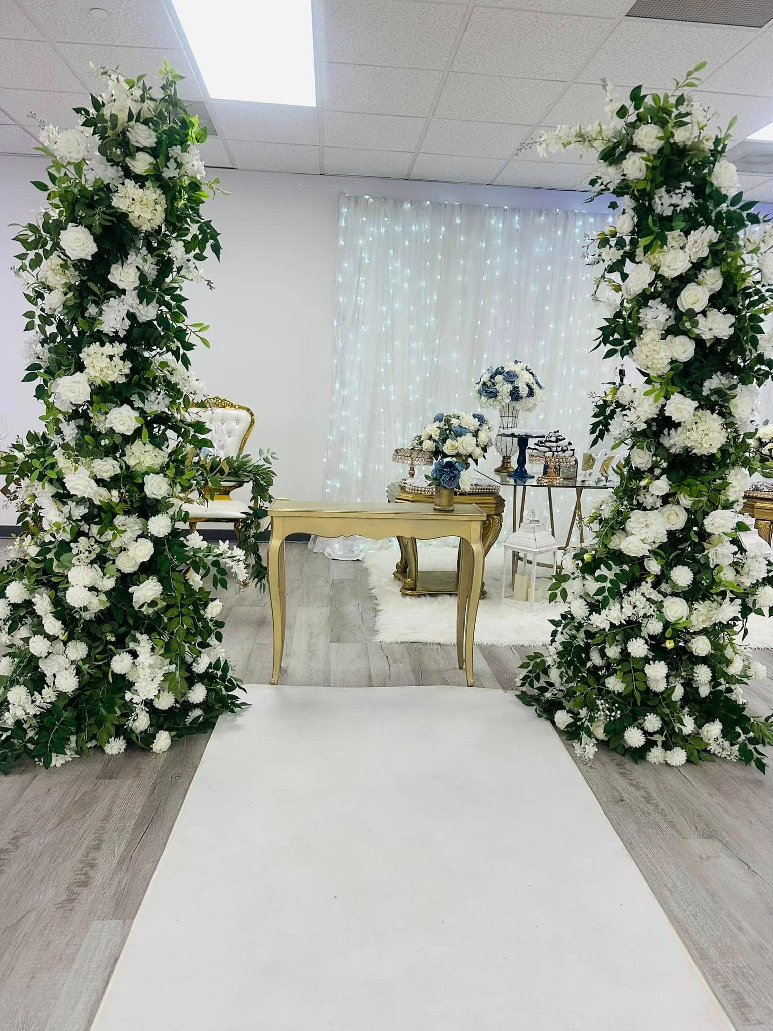 A room decorated with white flowers and greenery for a wedding ceremony.
