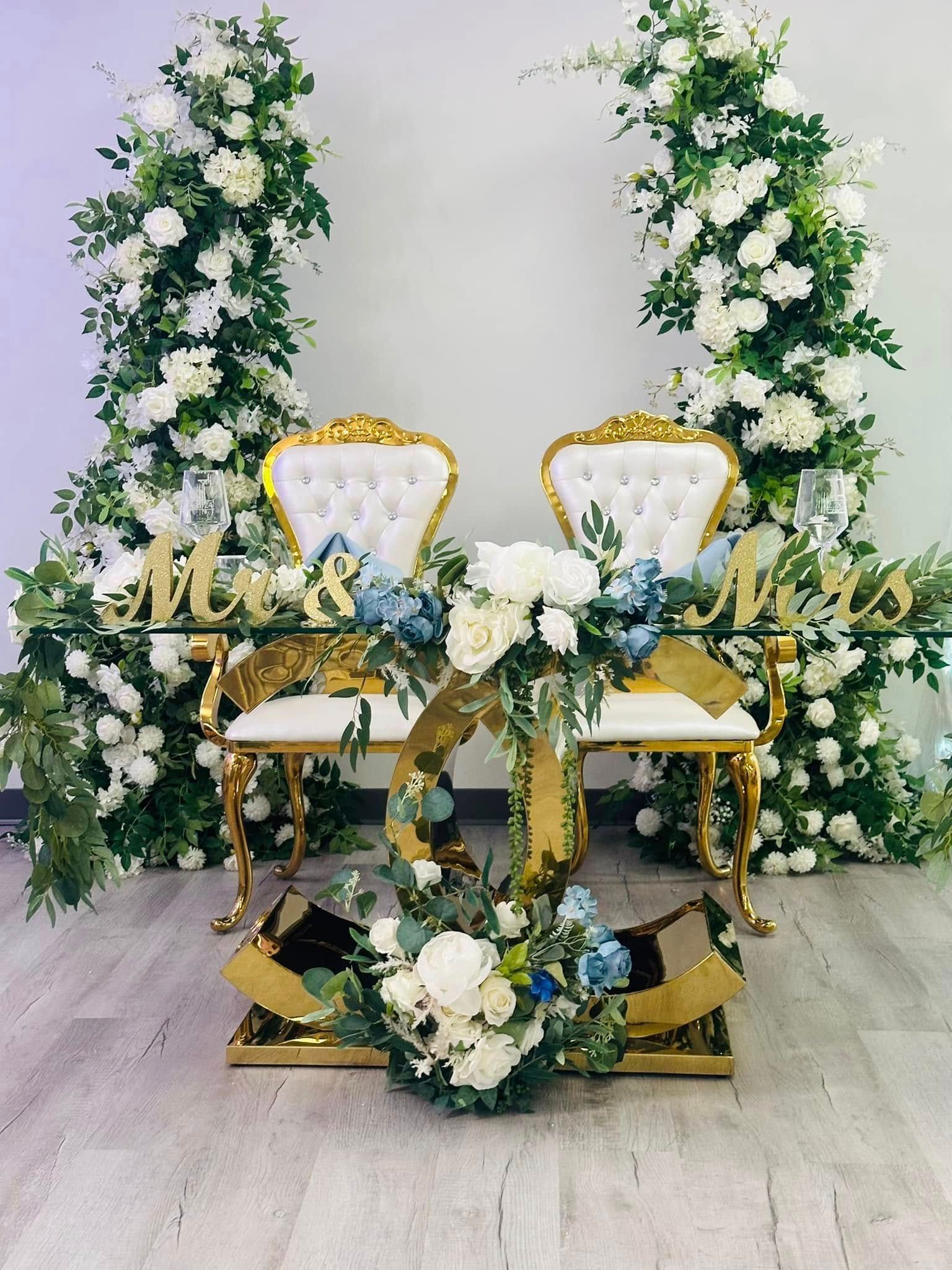 A couple of chairs sitting next to a table decorated with flowers.