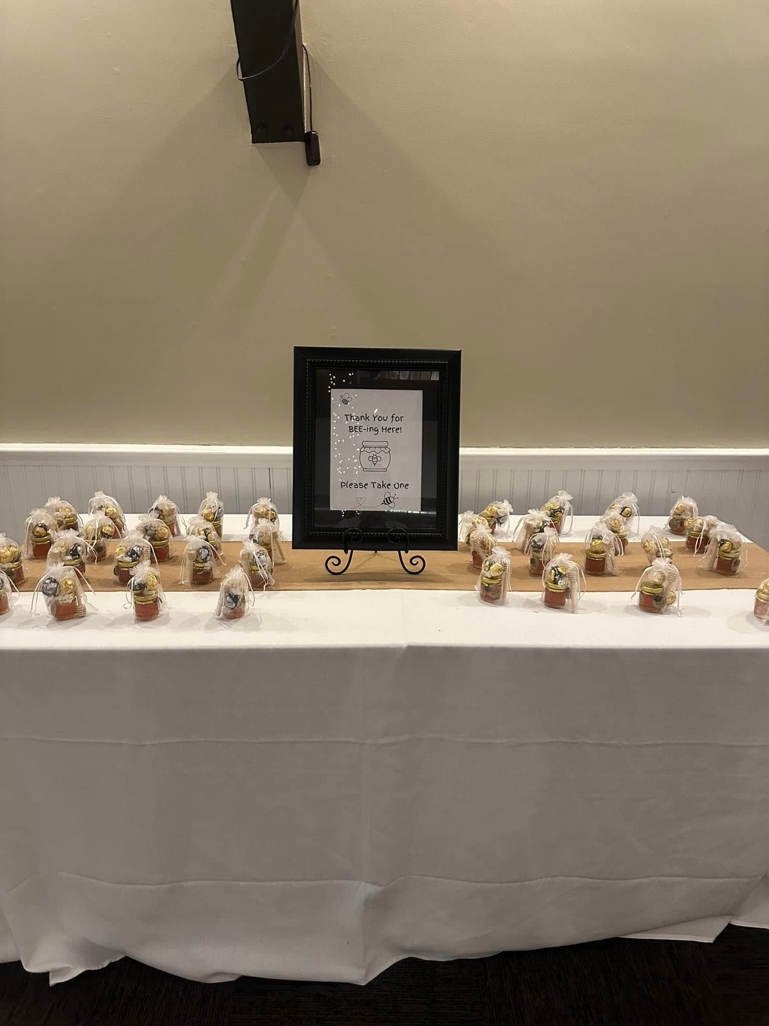 A table with a lot of cupcakes on it and a sign on it.