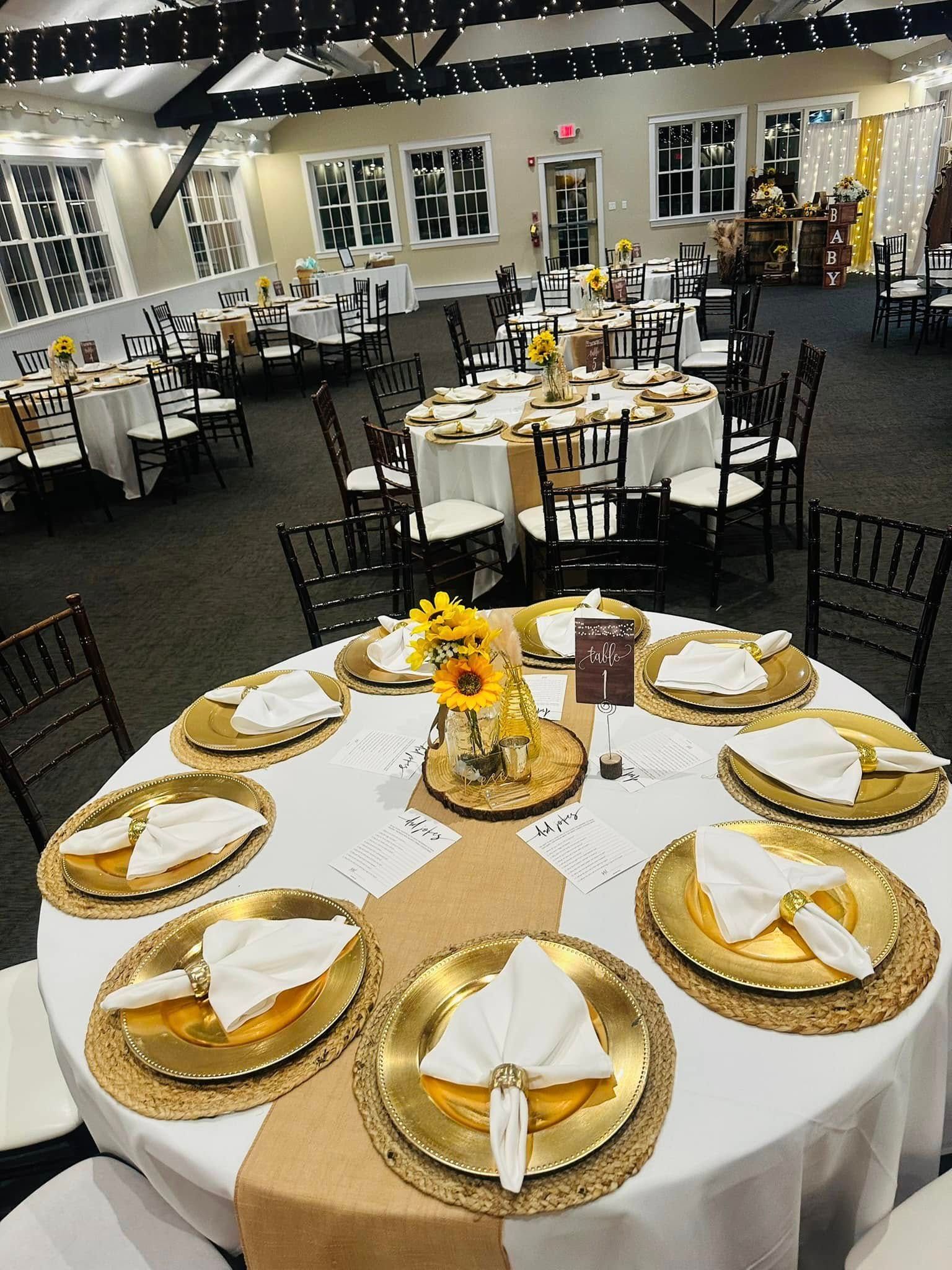 A large room with tables and chairs set up for a wedding reception.