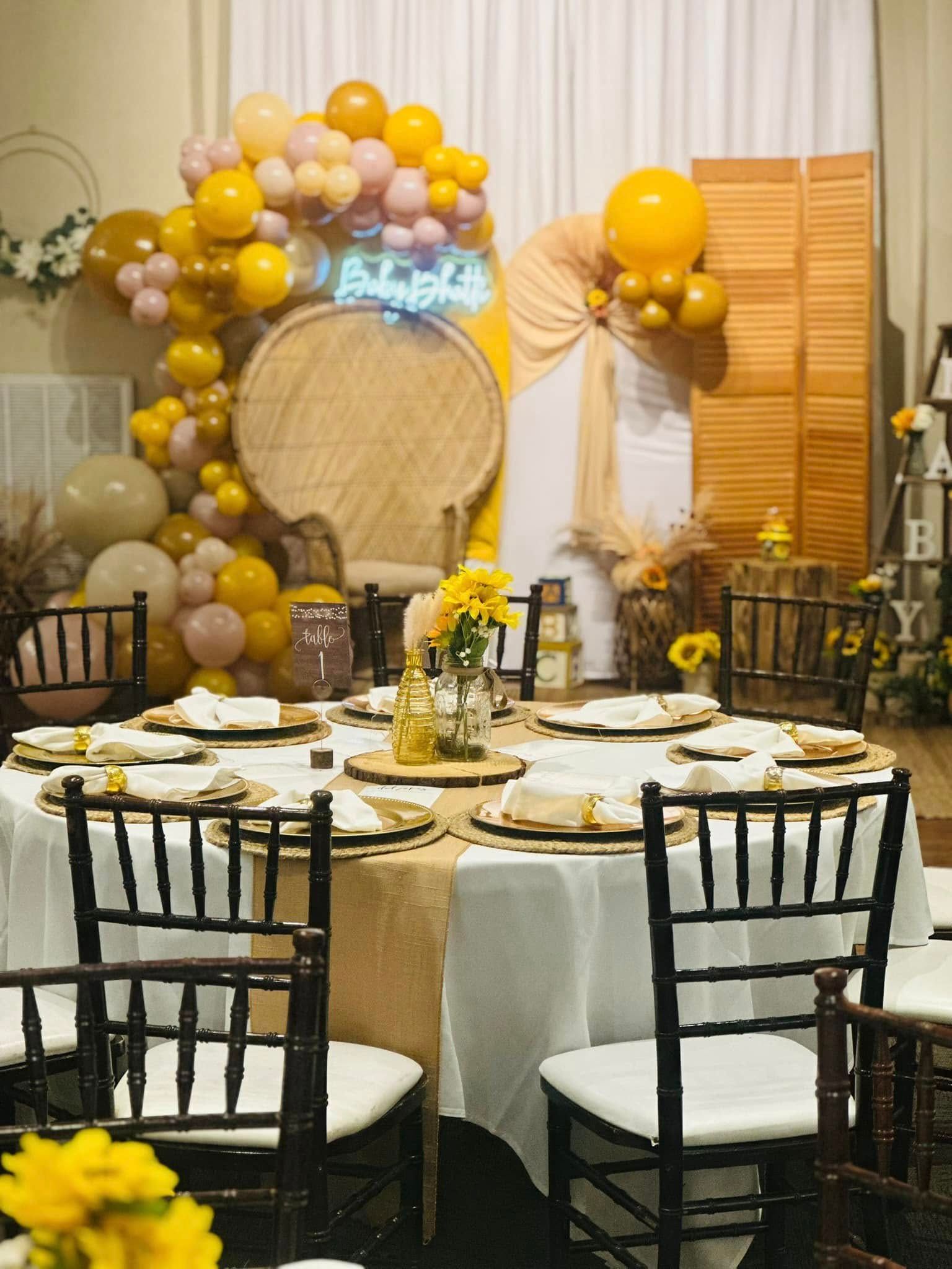 A room with tables and chairs and balloons on the wall.