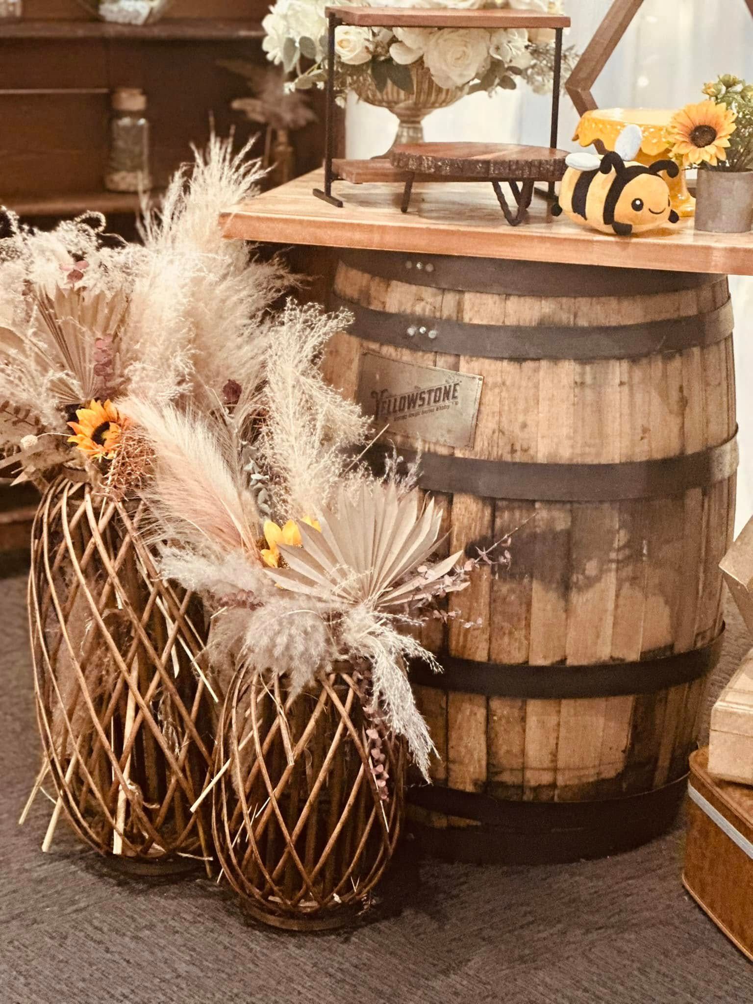 A wooden barrel with flowers in it is sitting on top of a table.
