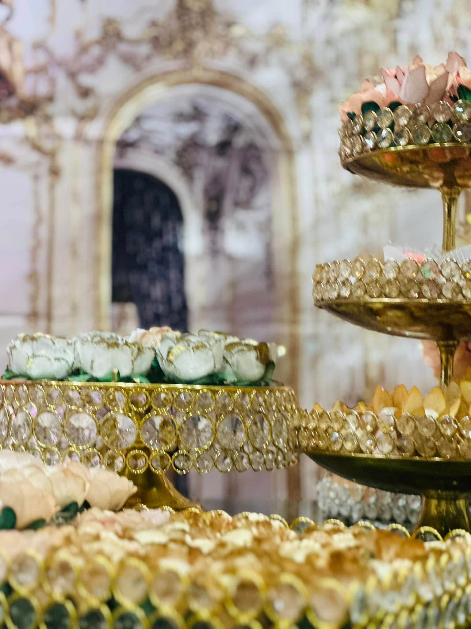 A stack of gold plates filled with food and flowers.