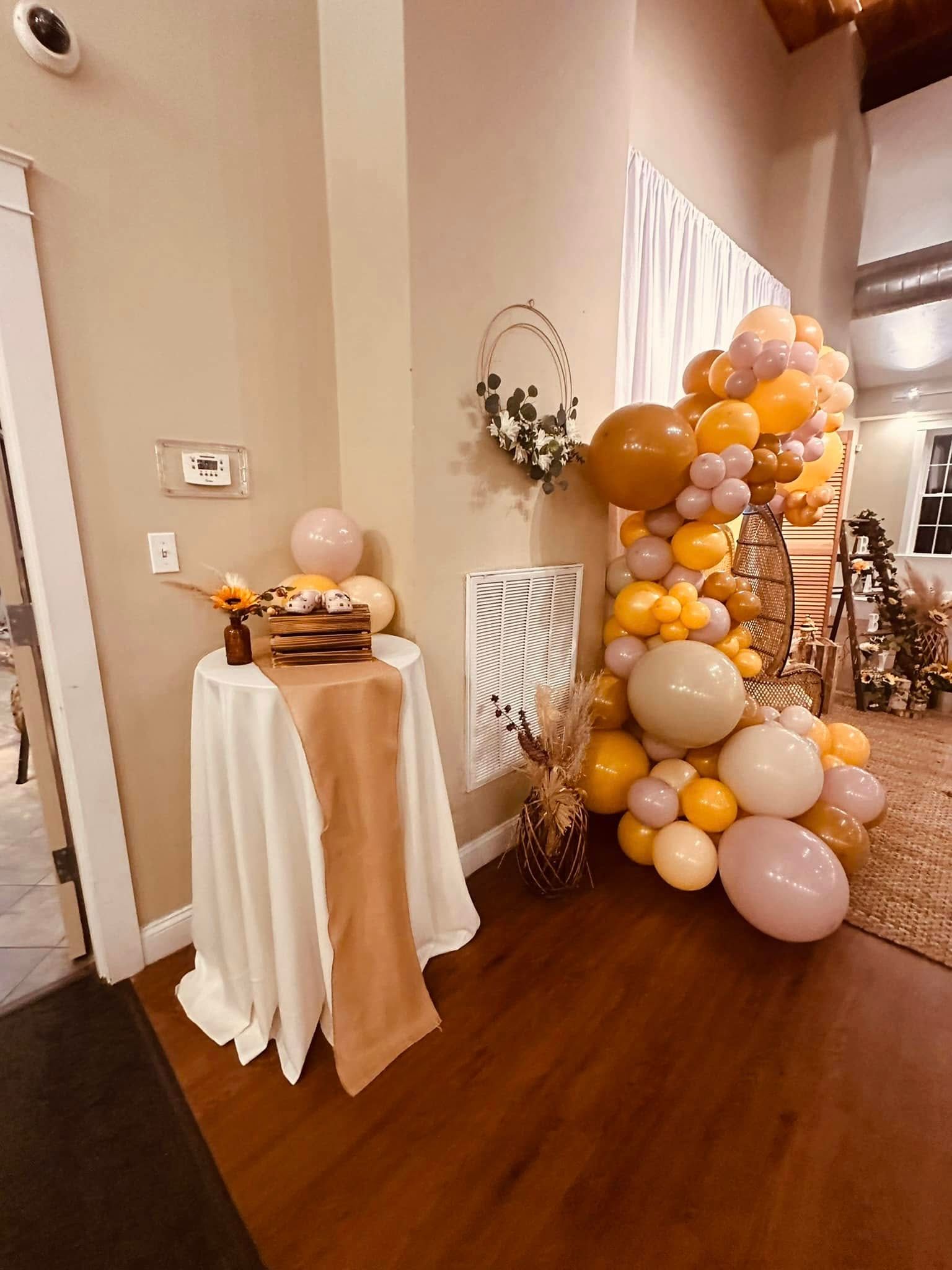 A room filled with balloons and a table with a cake on it.