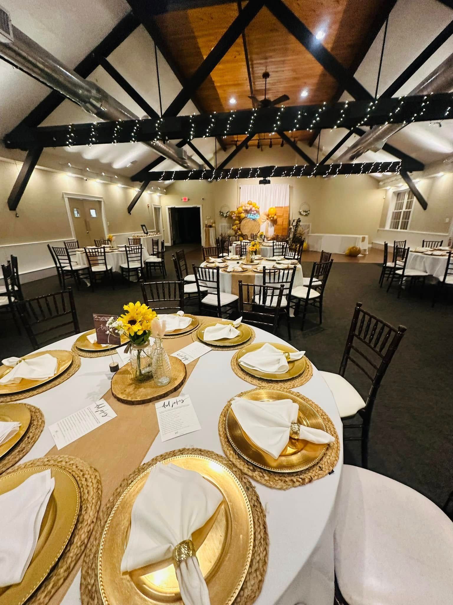 A large room with tables and chairs set up for a wedding reception.
