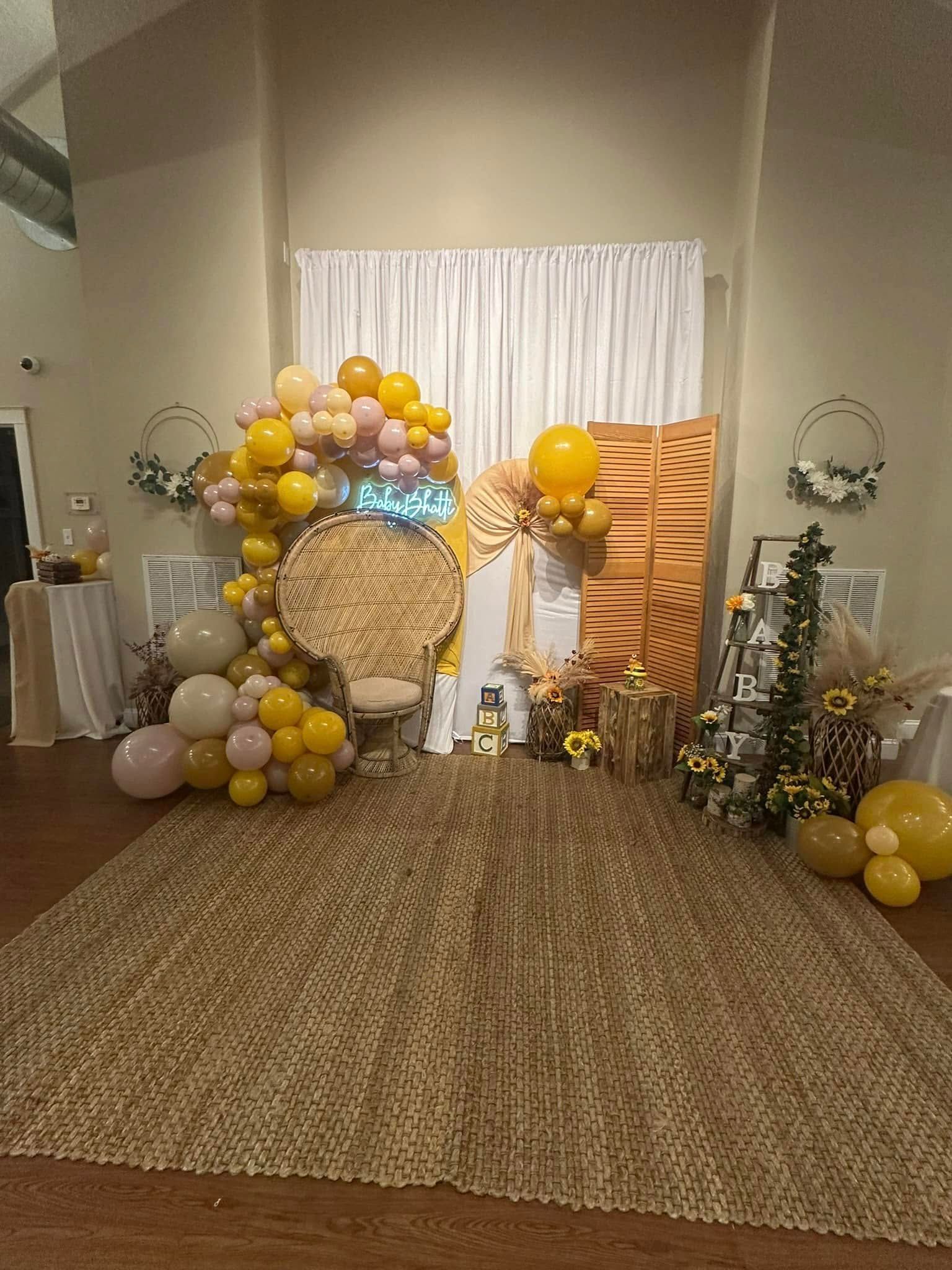 A room decorated with balloons and flowers for a baby shower.